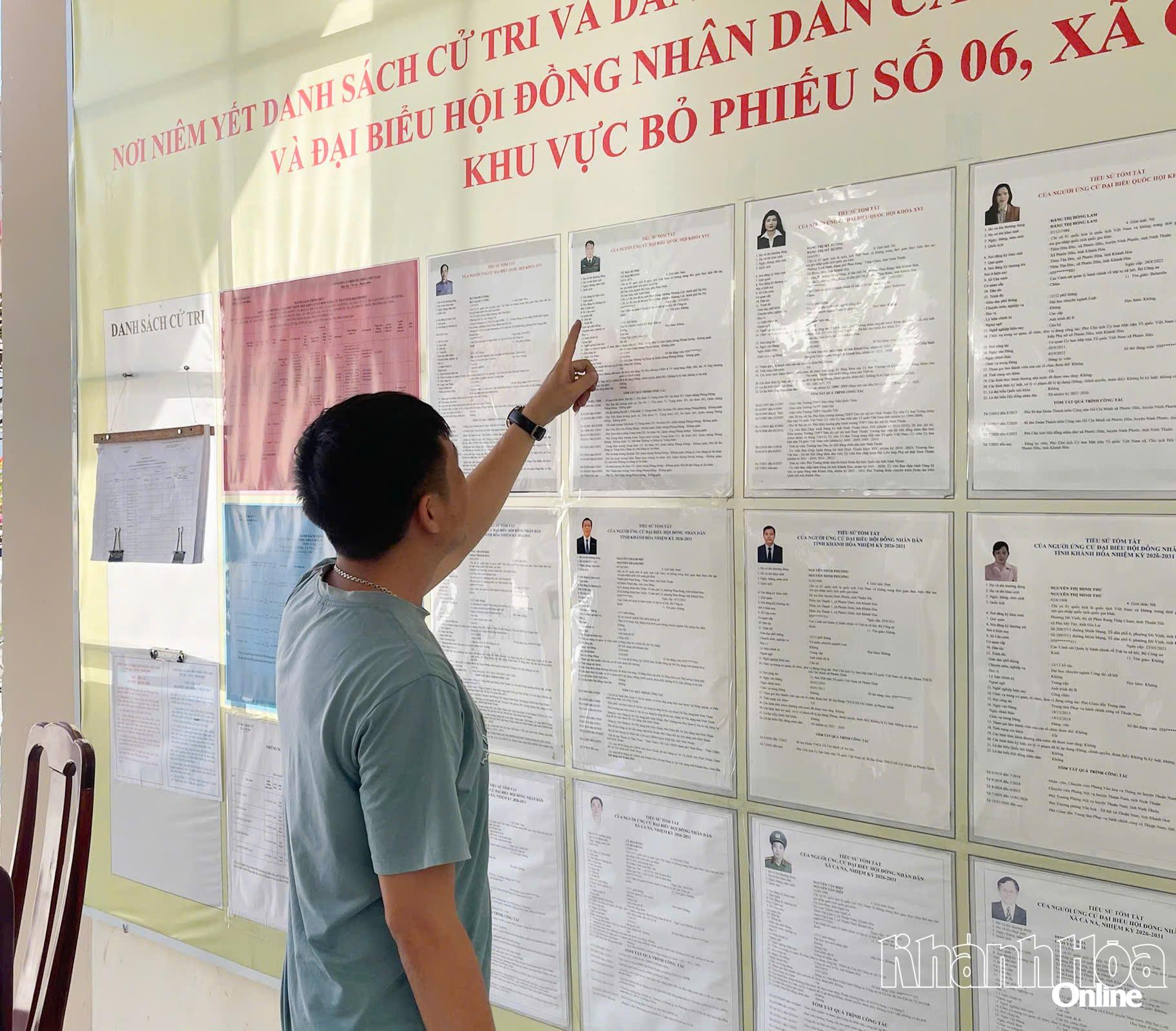 Một ngư dân thôn Lạc Tân 1 (xã Cà Ná) đang đọc tiểu sử các ứng cử viên