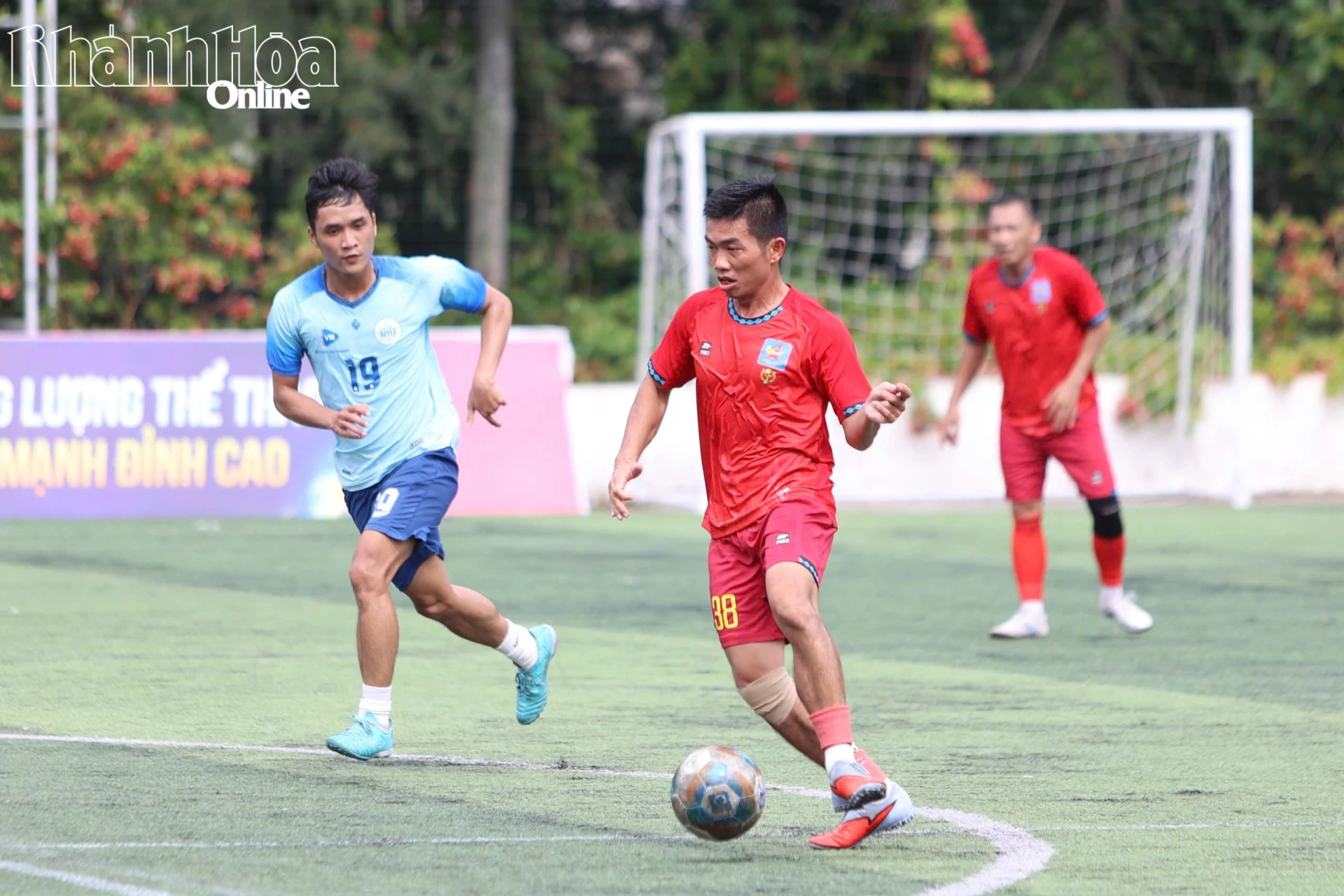 Những cầu thủ dân văn phòng đá bóng ở một sân cỏ nhân tạo.