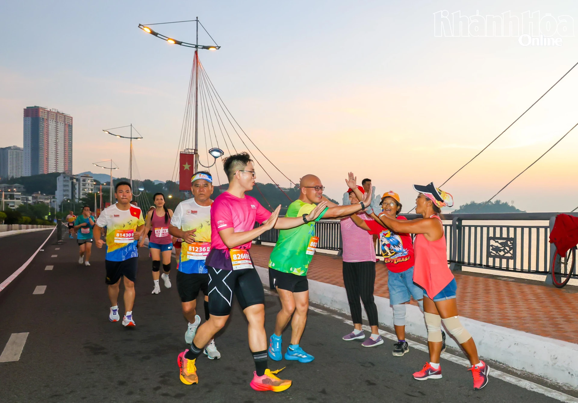 Người dân tập thể dục buổi sáng tranh thủ cổ động cho các runner.