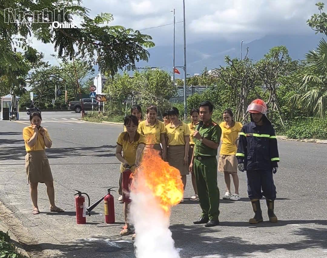 Cán bộ, giáo viên nhà trường được thực hành sử dụng bình chữa cháy xách tay để dập lửa.