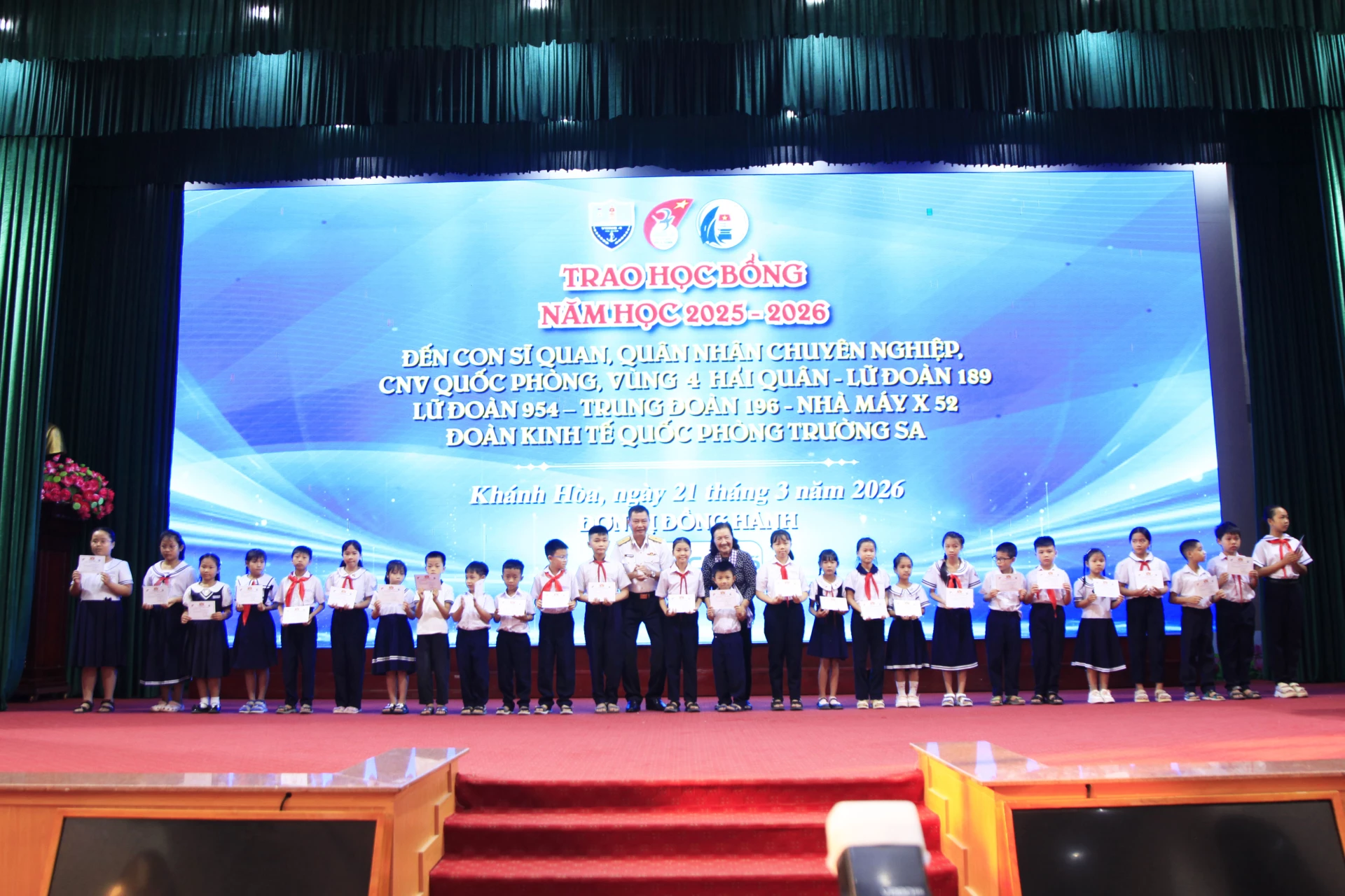 Chuẩn đô đốc Nguyễn Anh Tuấn cùng đại diện đoàn công tác trao chứng nhận học bổng cho các cháu học sinh tiểu học.