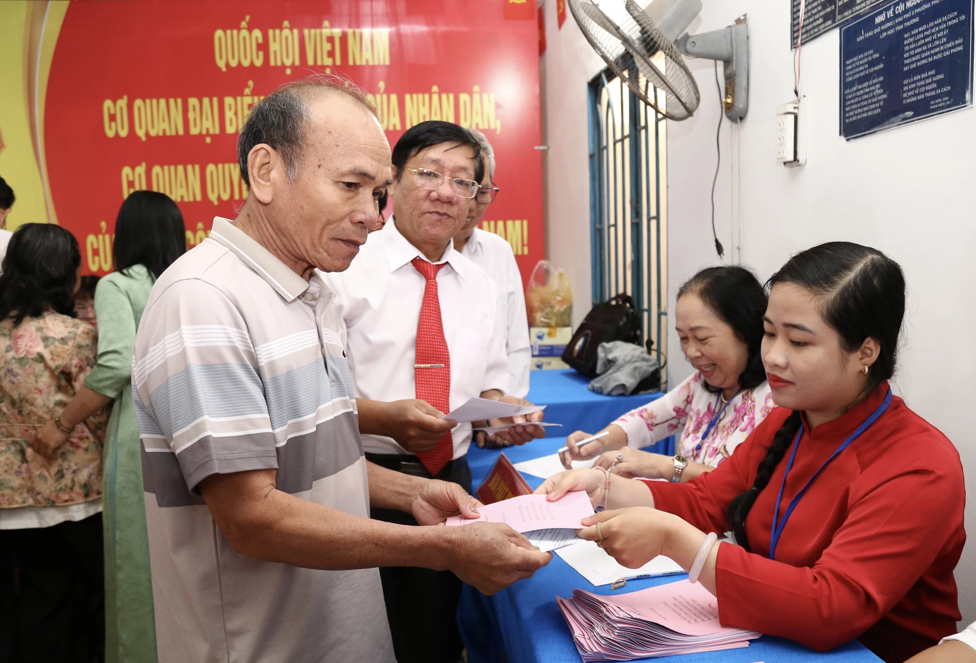Cử tri nhận phiếu bầu để tham gia bầu cử tại Khu vực bỏ phiếu số 4 (phường Phan Rang). Ảnh: Thanh Long.
