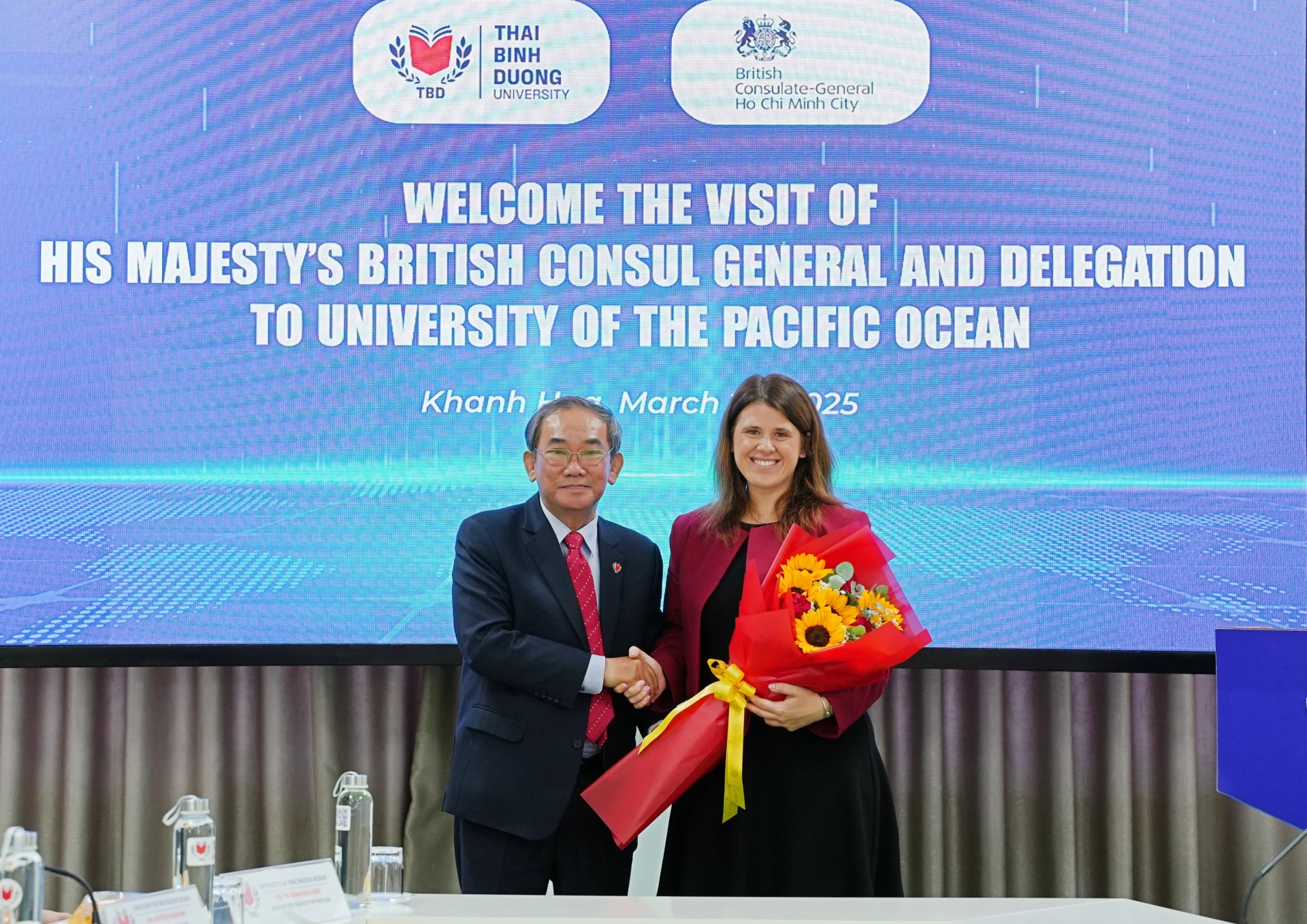 Nhà giáo Nhân dân, Phó Giáo sư, Tiến sĩ Hồ Thanh Phong tặng hoa cho bà Alexandra Smith.