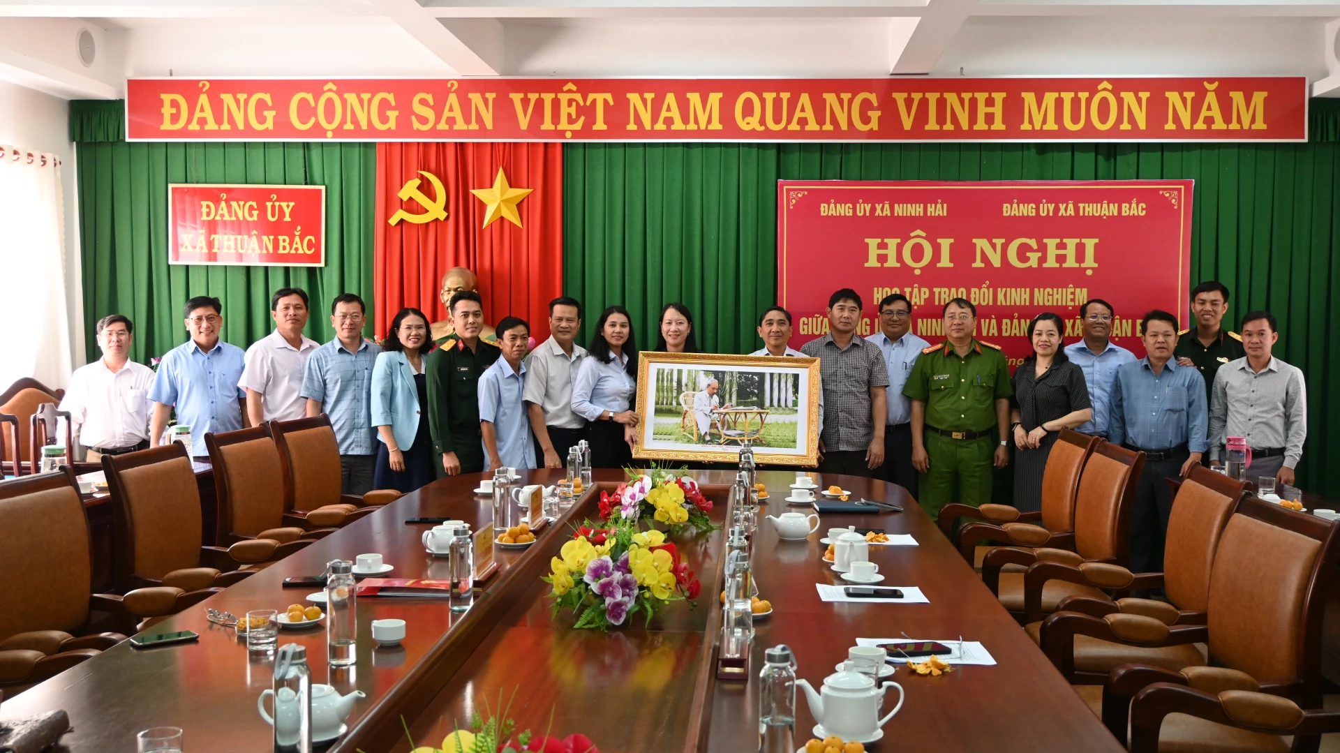 Lãnh đạo hai xã trao bức tranh kỷ niệm.