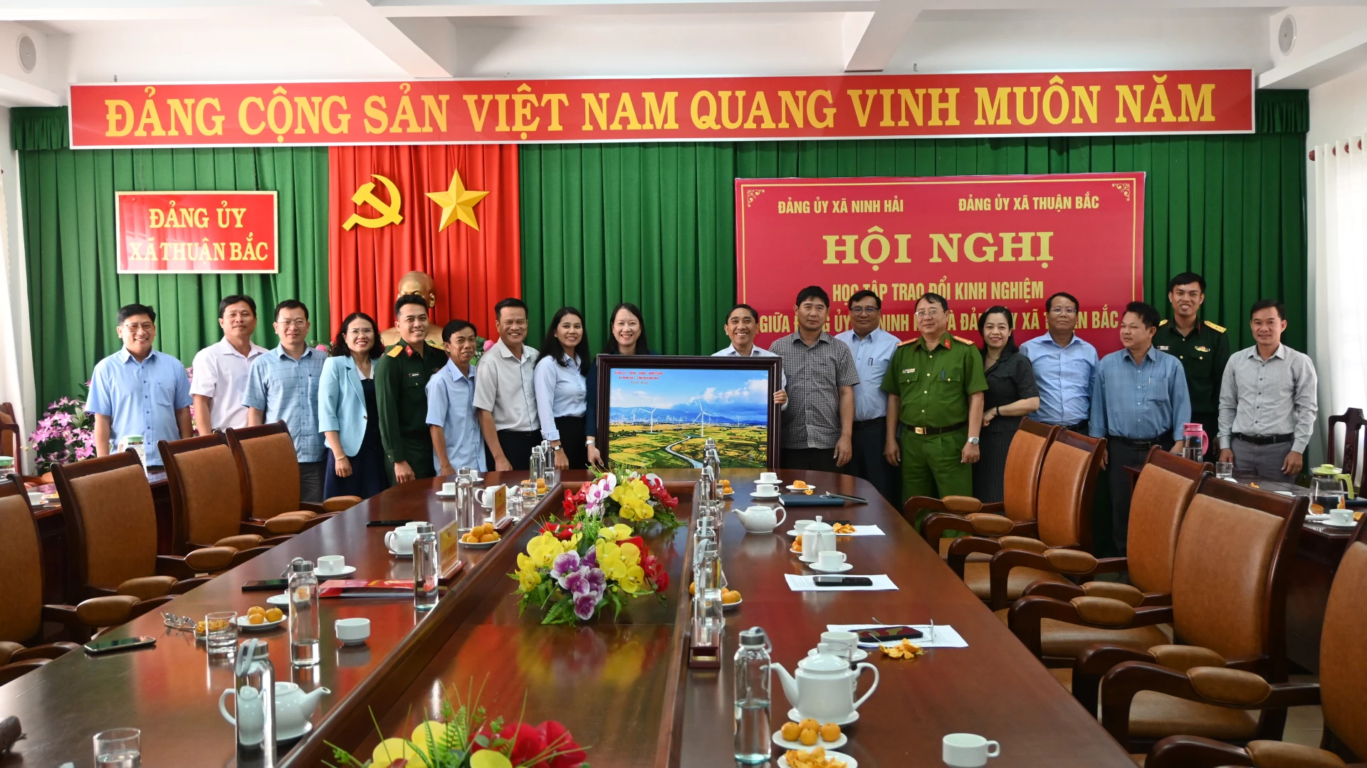 Lãnh đạo hai xã trao bức tranh kỷ niệm.