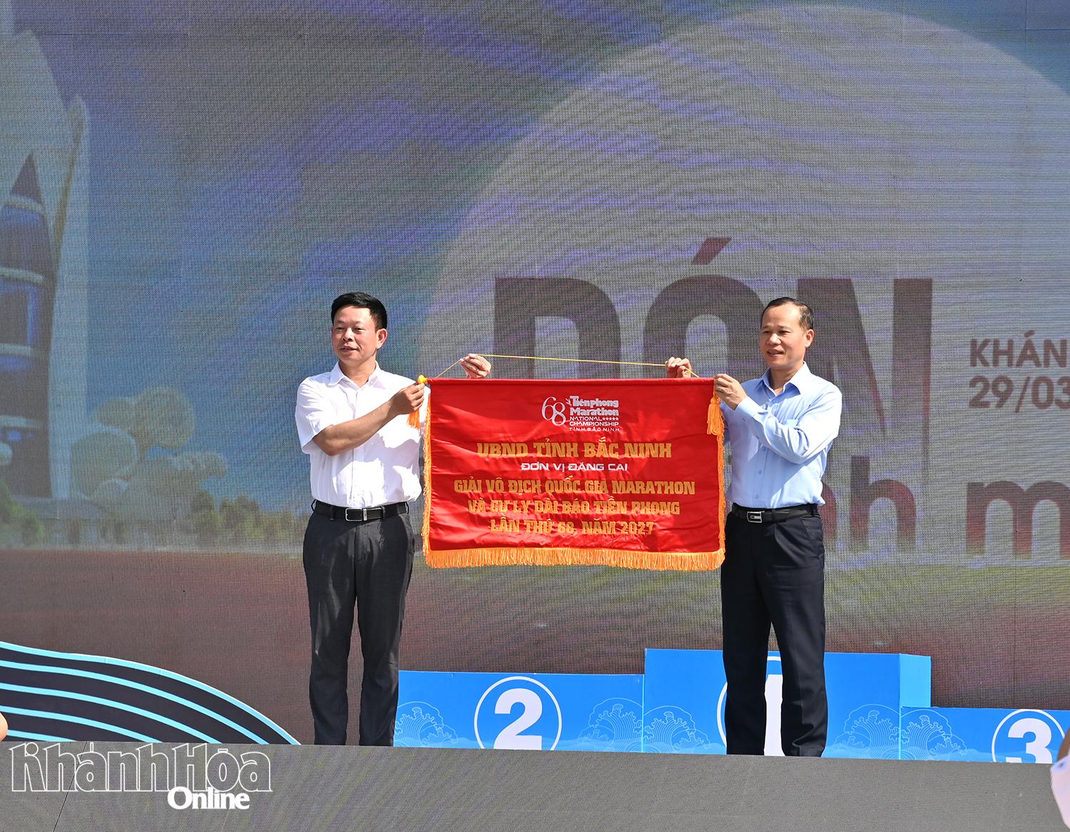 Nhà báo Phùng Công Sưởng-Tổng Biên tập Báo Tiền Phong trao cờ đăng cai Giải vô địch quốc gia Marathon Báo Tiền Phong lần thứ 68 cho lãnh đạo tỉnh Bắc Ninh.