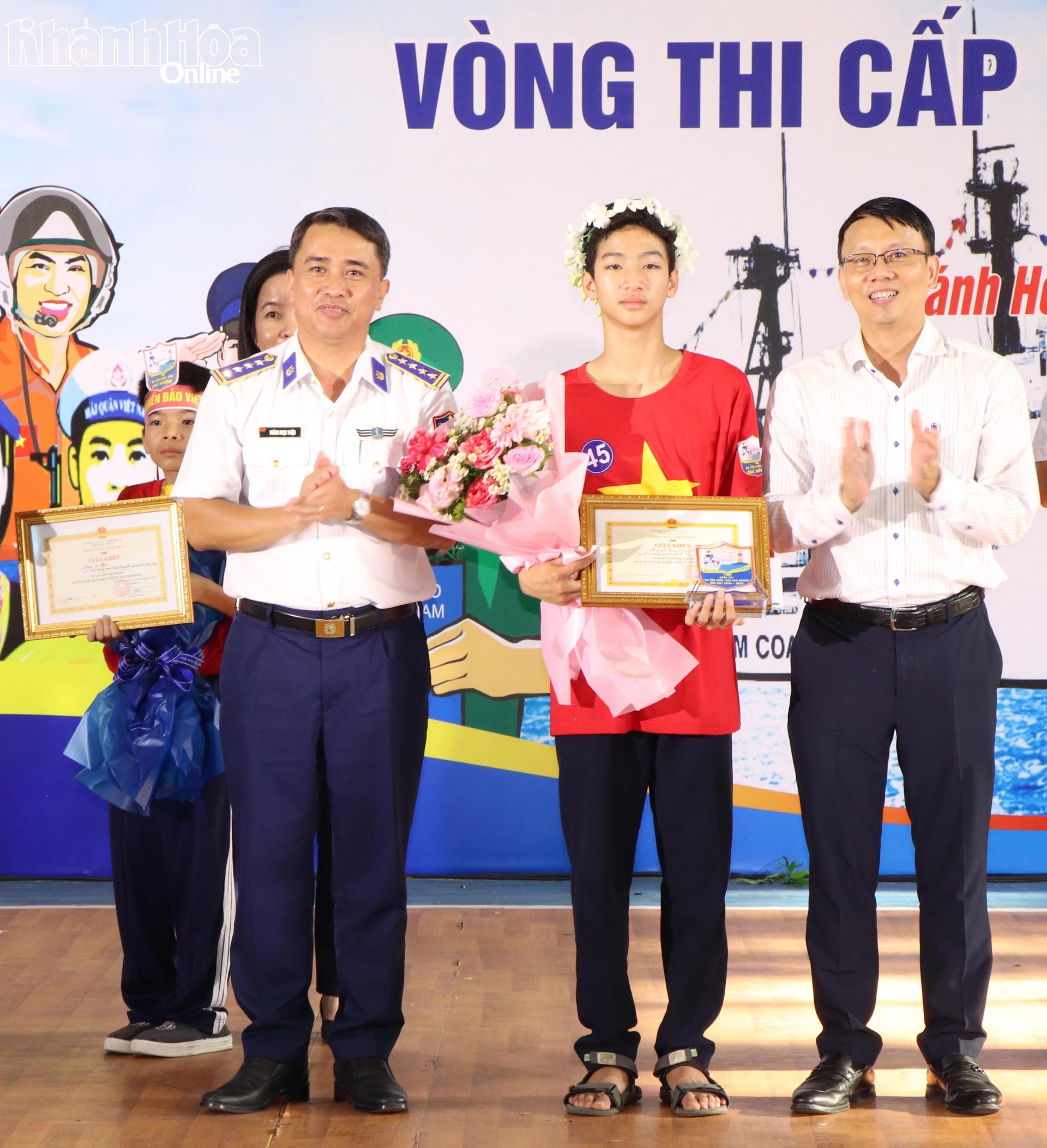 Đồng chí Nguyễn Thanh Hà và Đại tá Hoàng Ngọc Thiện trao giải nhất cho em Nguyễn Huy Hoàng Nam.