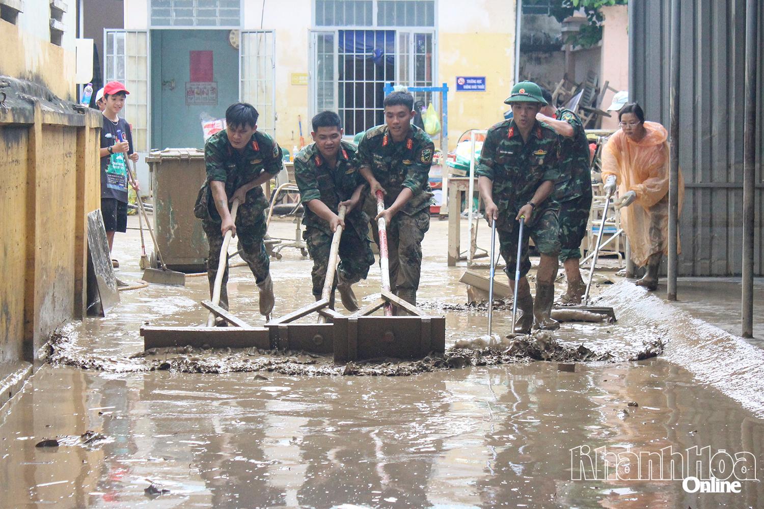 Cán bộ, chiến sĩ giúp người dân xã Diên Khánh dọn vệ sinh sau lũ.