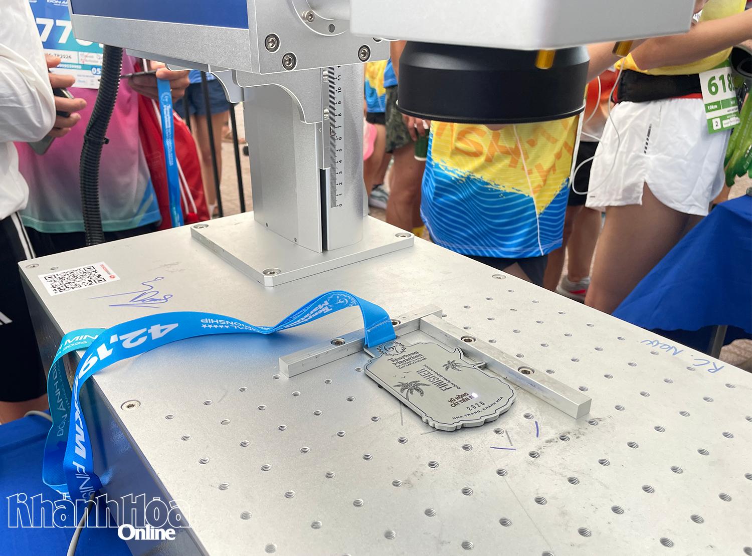 Chiếc huy chương hoàn thành cự ly đang được máy khắc tên.