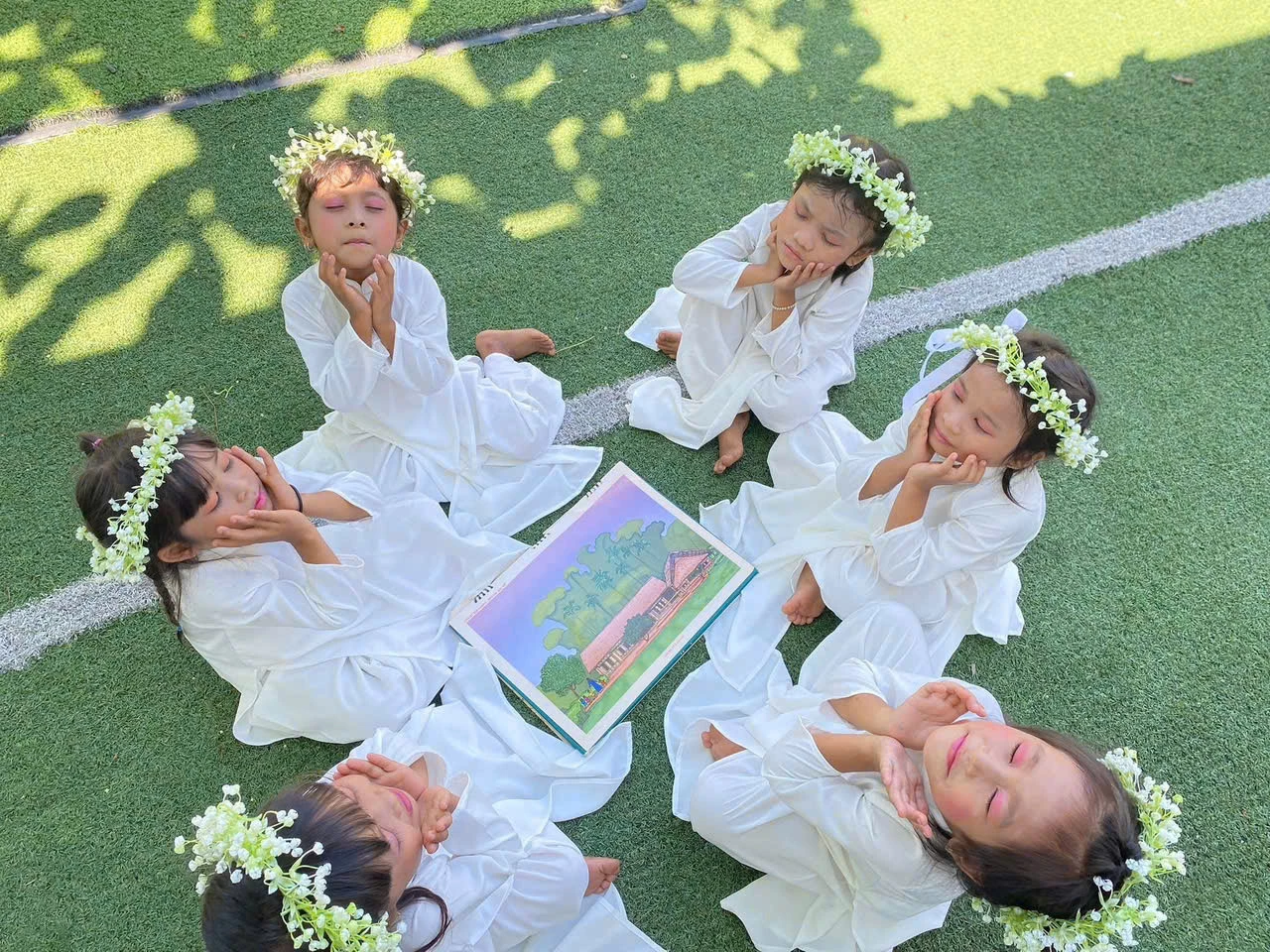 Các em nhỏ Trường Mầm non Anh Đào, xã Nam Khánh Vĩnh chụp ảnh trong trang phục áo dài trắng, tạo nên những khoảnh khắc đáng yêu và trong sáng.