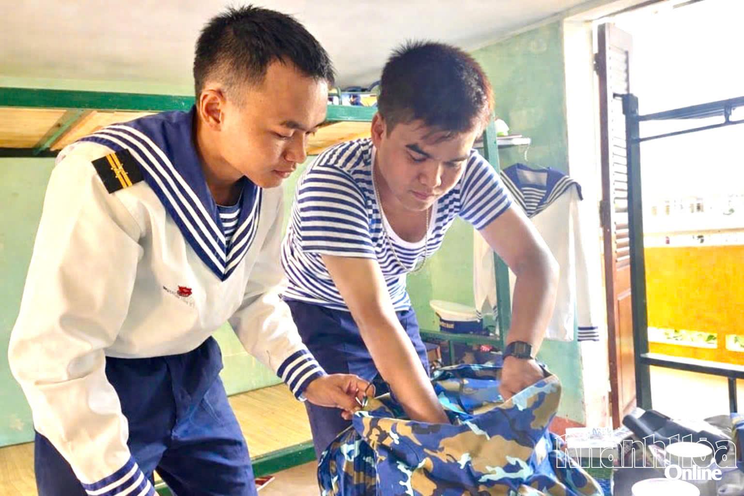 Một Tiểu đội trưởng hướng dẫn chiến sĩ mới sắp đặt quân tư trang