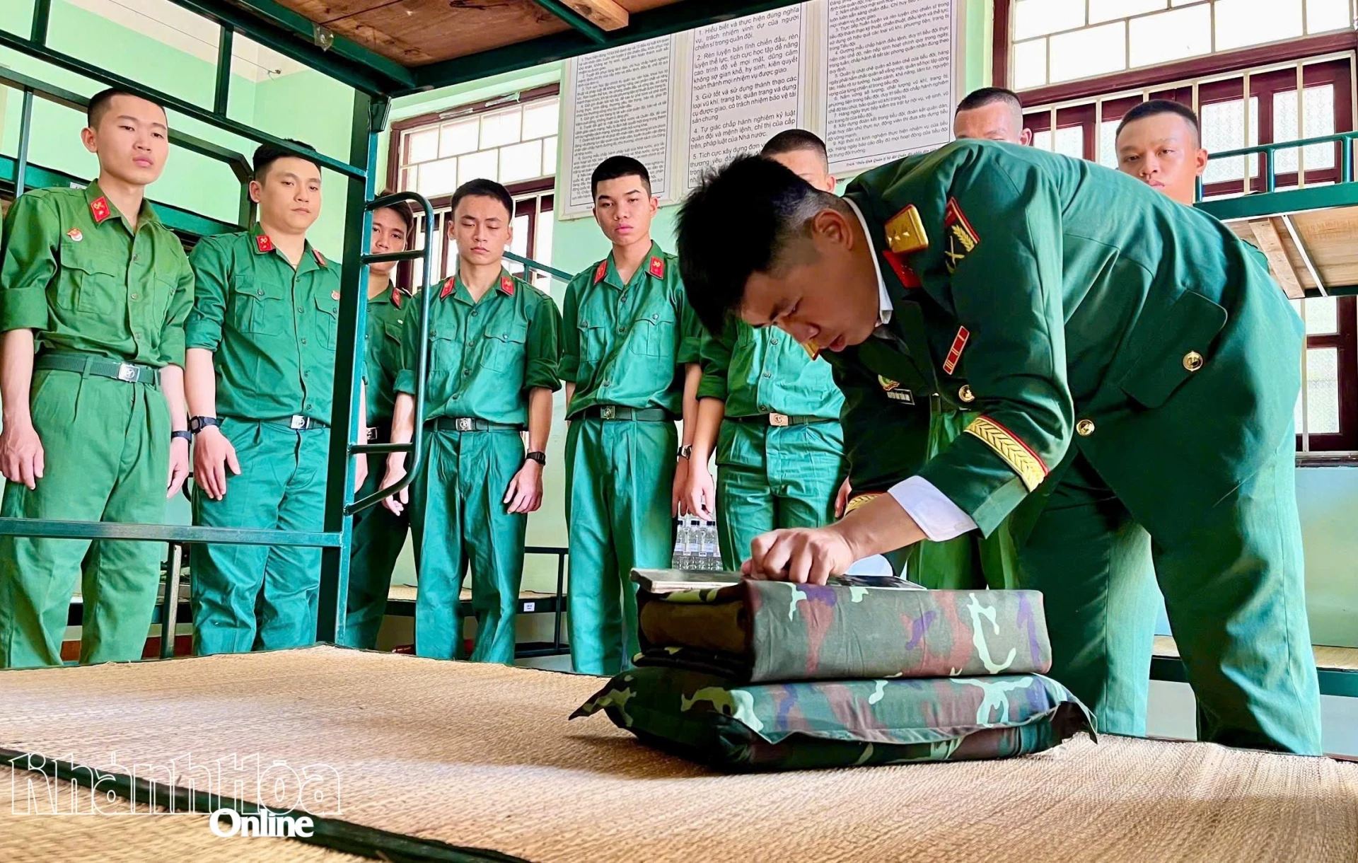 Chiến sĩ mới được cán bộ hướng dẫn gấp xếp nội vụ.