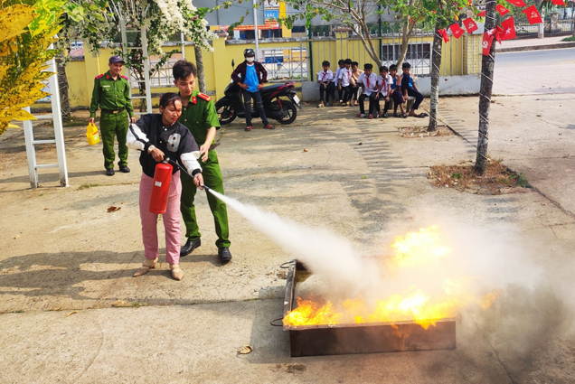 Cán bộ chữa cháy hướng dẫn kỹ năng dập tắt đám cháy cho người dân xã Ba Cụm Bắc.