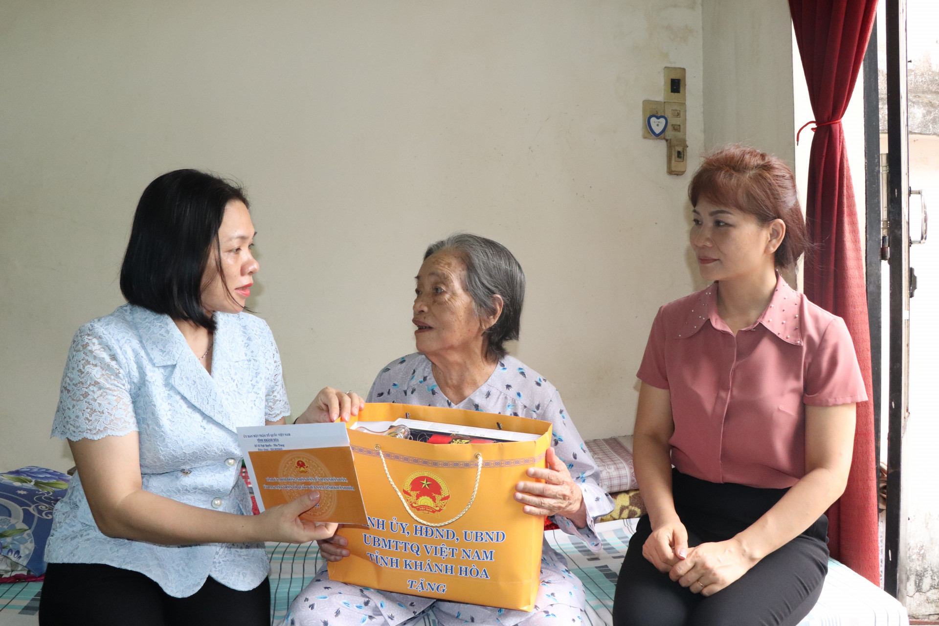 Bà Trần Thu Mai hỏi thăm và tặng quà cho bà Hoàng Thị Bình.