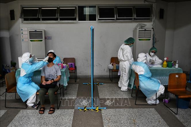 Nhân viên y tế lấy mẫu xét nghiệm COVID-19 tại Bangkok, Thái Lan. Ảnh tư liệu: AFP/TTXVN

