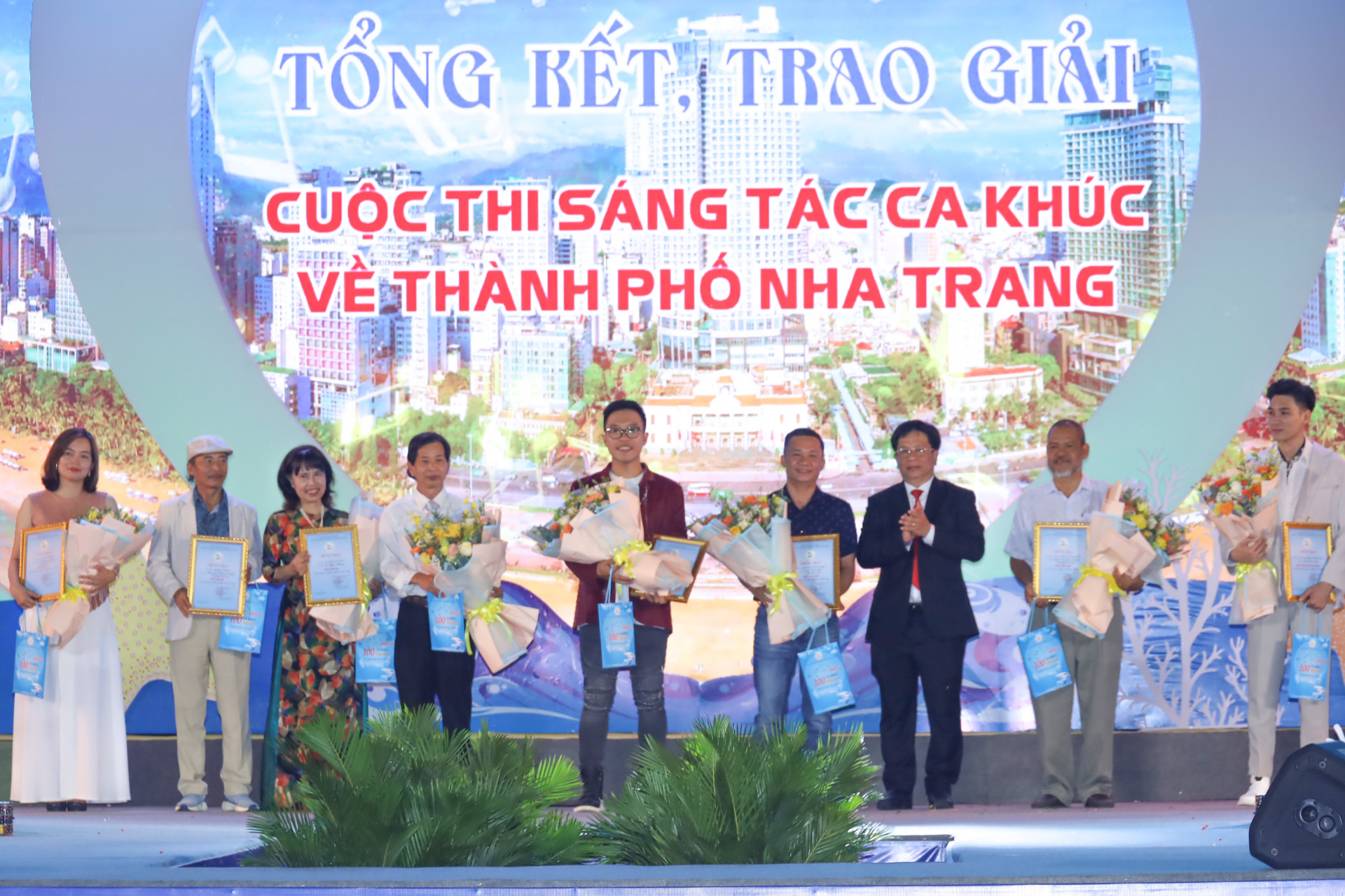 Ho Van Mung giving prizes to Le Thanh Nhat Minh and other contest winners.

