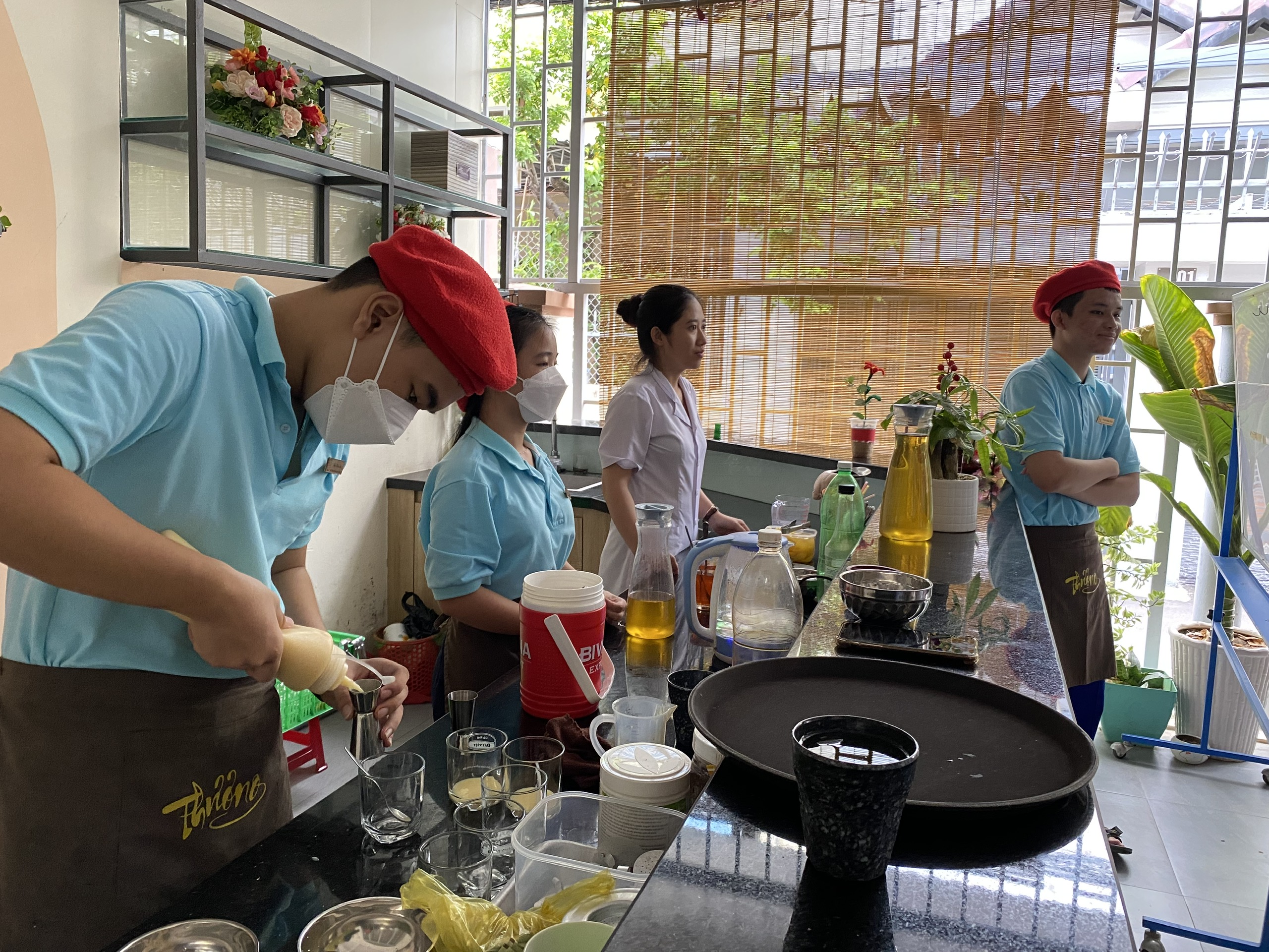 Học sinh của Trung tâm Phục hồi chức năng - Giáo dục trẻ khuyết tật thực hành pha chế tại quán Cà phê Thương.