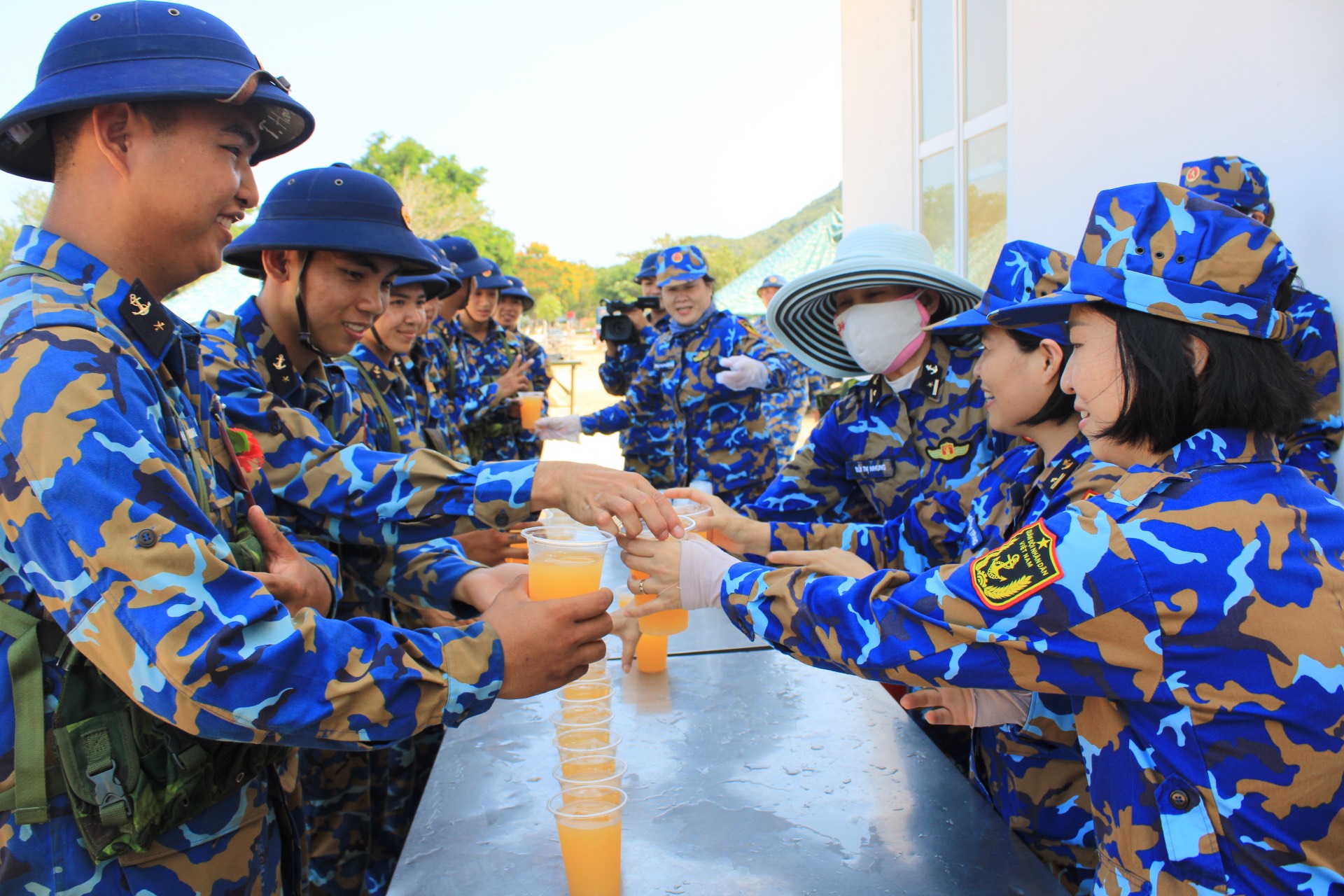 Cán bộ, hội viên phụ nữ phục vụ nước cho các cán bộ chiến sĩ sau giờ huấn luyện ở thao trường