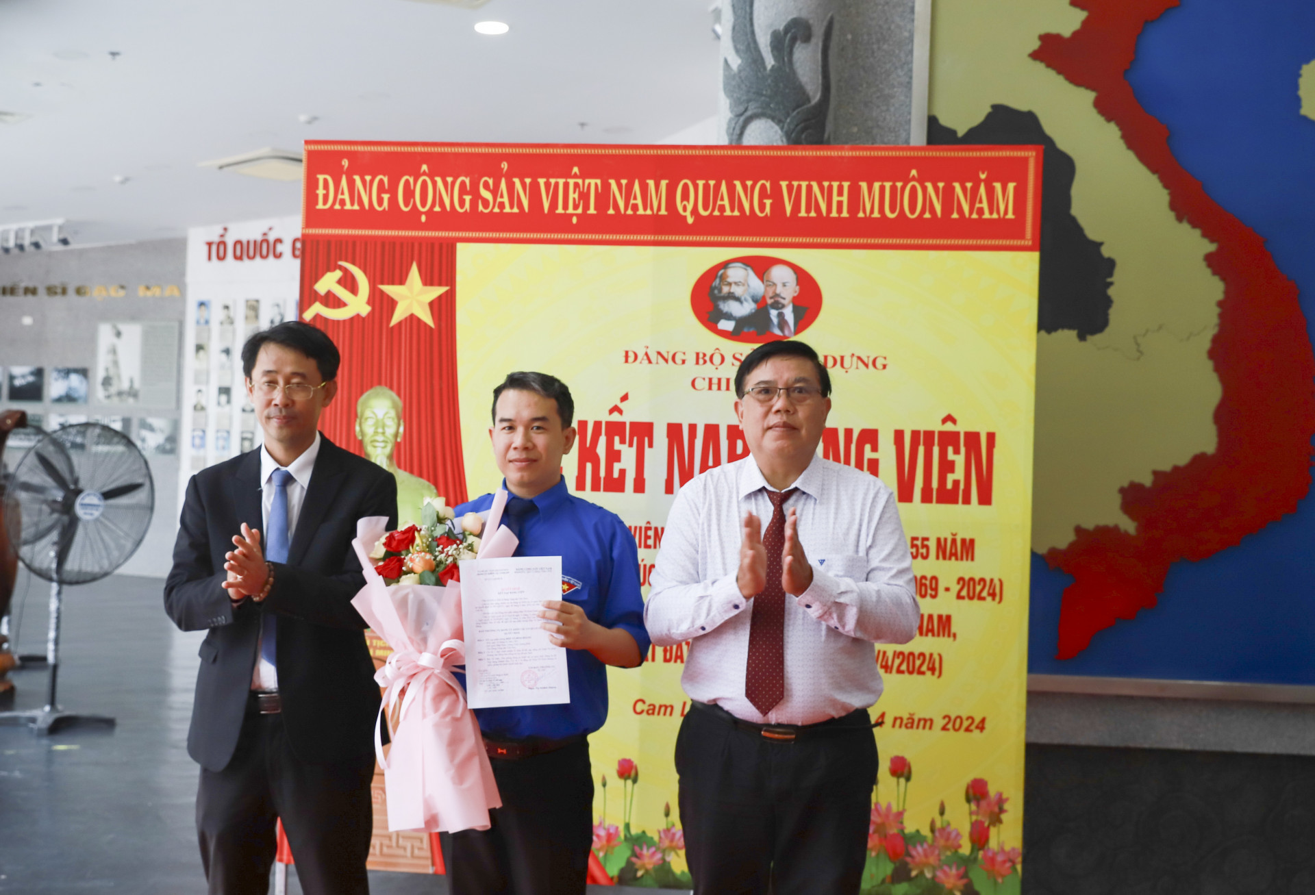 Ông Trịnh Văn Mơ - Phó Bí thư Đảng ủy Khối các cơ quan tỉnh (bên trái) và lãnh đạo Sở Xây dựng trao quyết định, tặng hoa chúc mừng đảng viên mới Diệp Võ Đinh Hoàng.