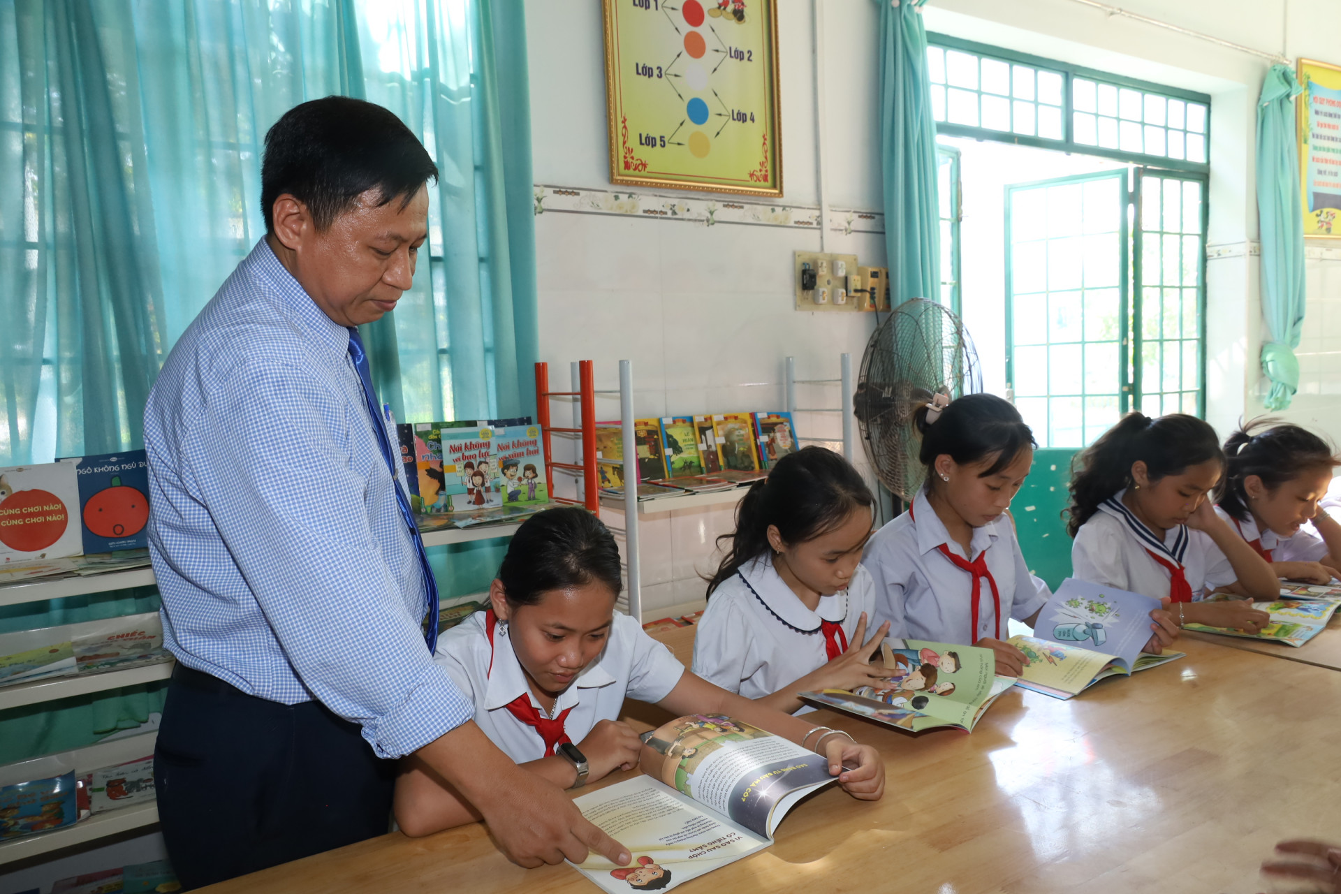 Ông Đỗ Chí Kiên hướng dẫn học sinh trong một buổi đọc sách tại thư viện trường.