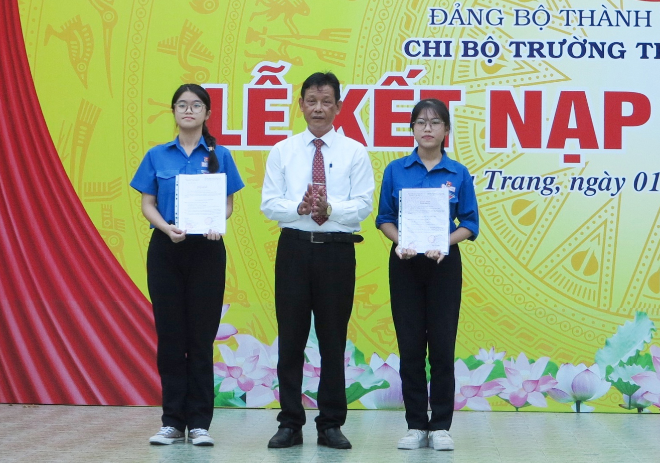 Thầy Trương Minh Trình trao quyết định kết nạp đảng viên cho 2 học sinh.
