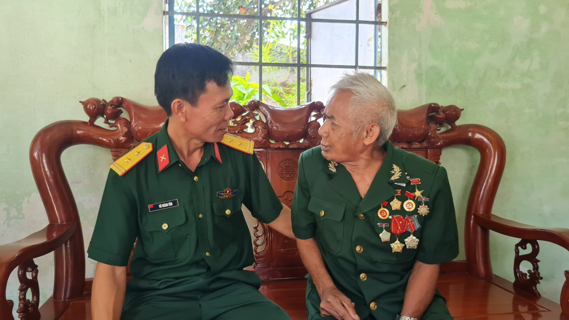 Anh hùng Bo Bo Tới trò chuyện với cán bộ Ban Chỉ huy Quân sự huyện Khánh Sơn.