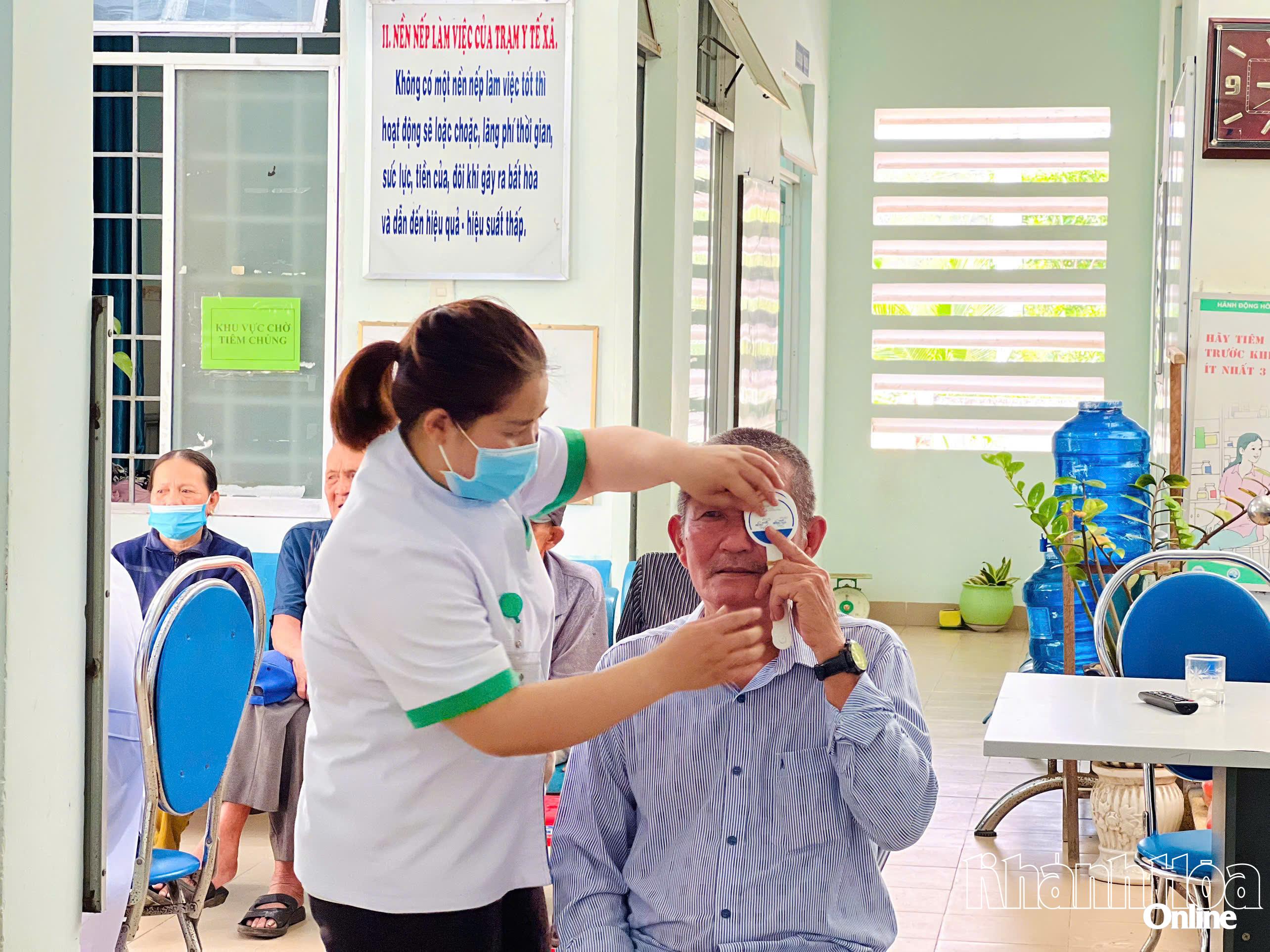 Một người dân được hỗ trợ các bước kiểm tra thị lực mắt