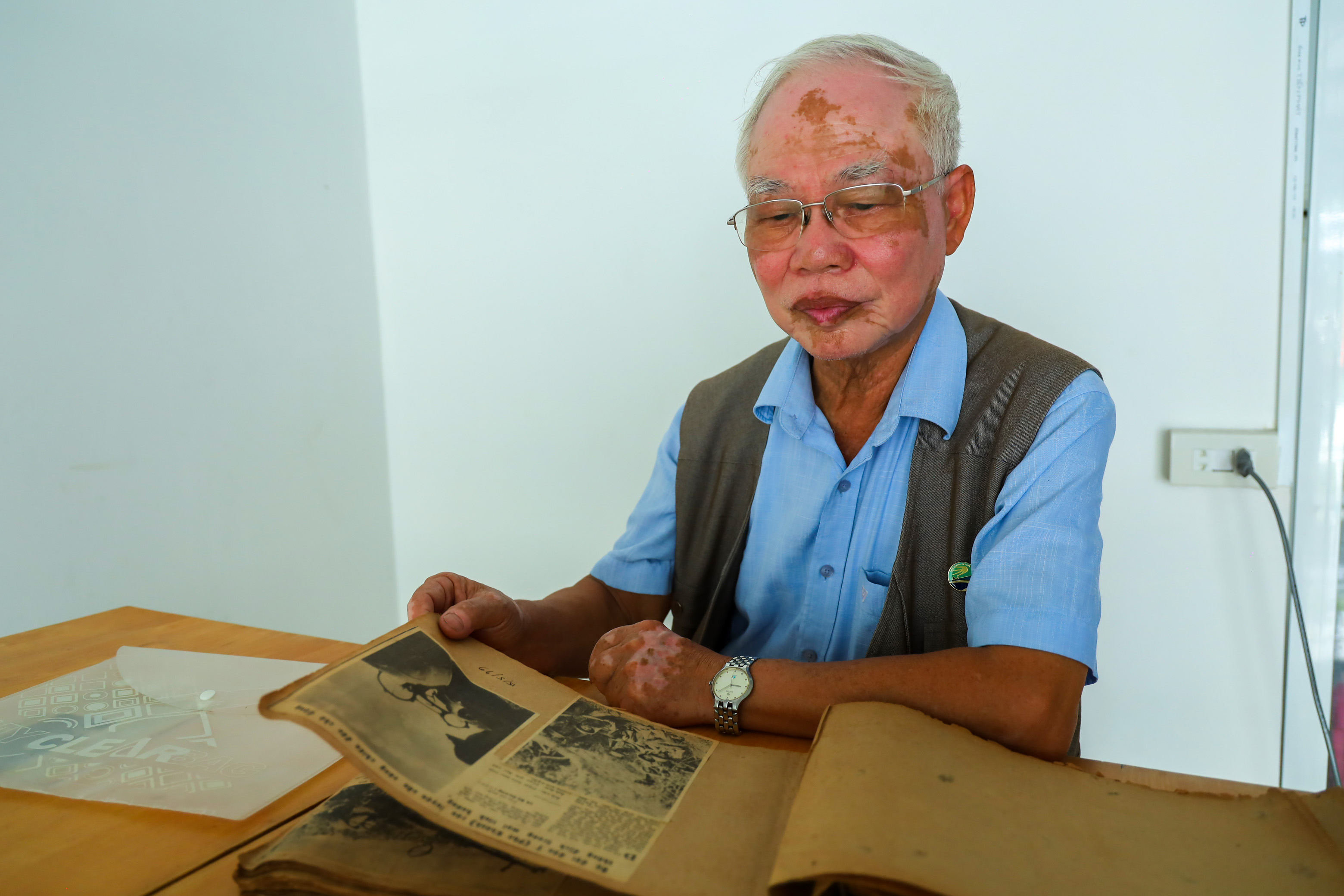 Nhà báo Lê Bá Dương lật giở những trang sổ có dán các tác phẩm được đăng trên Báo Phú Khánh và Báo Khánh Hòa.