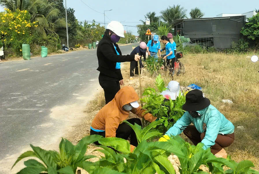 Cán bộ, hội viên phụ nữ xã trồng hoa dọc tuyến đường.