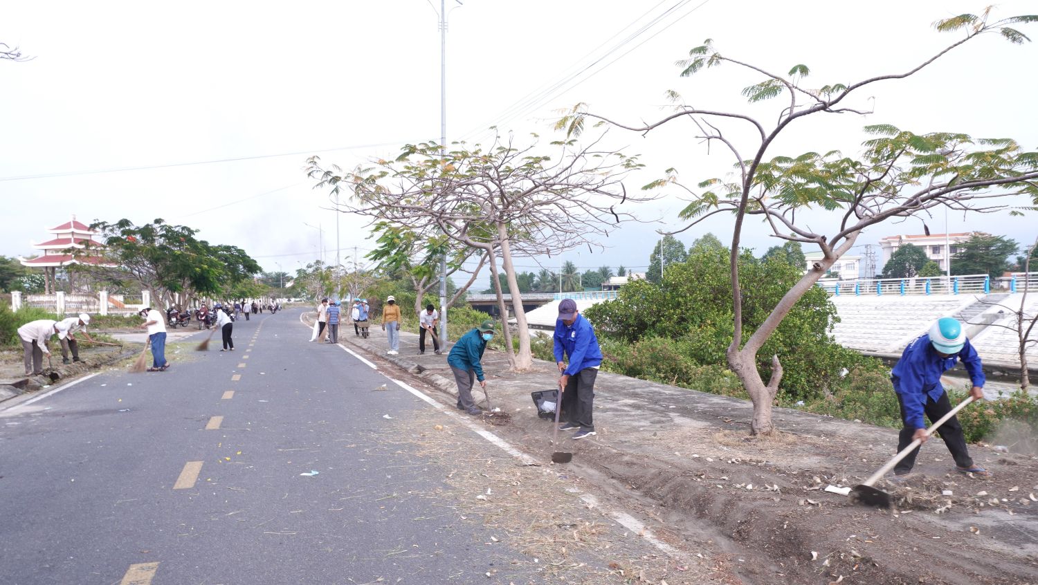Đoàn viên, hội viên, cán bộ và các tầng lớp nhân dân dọn vệ sinh môi trường trên đường 14-8.