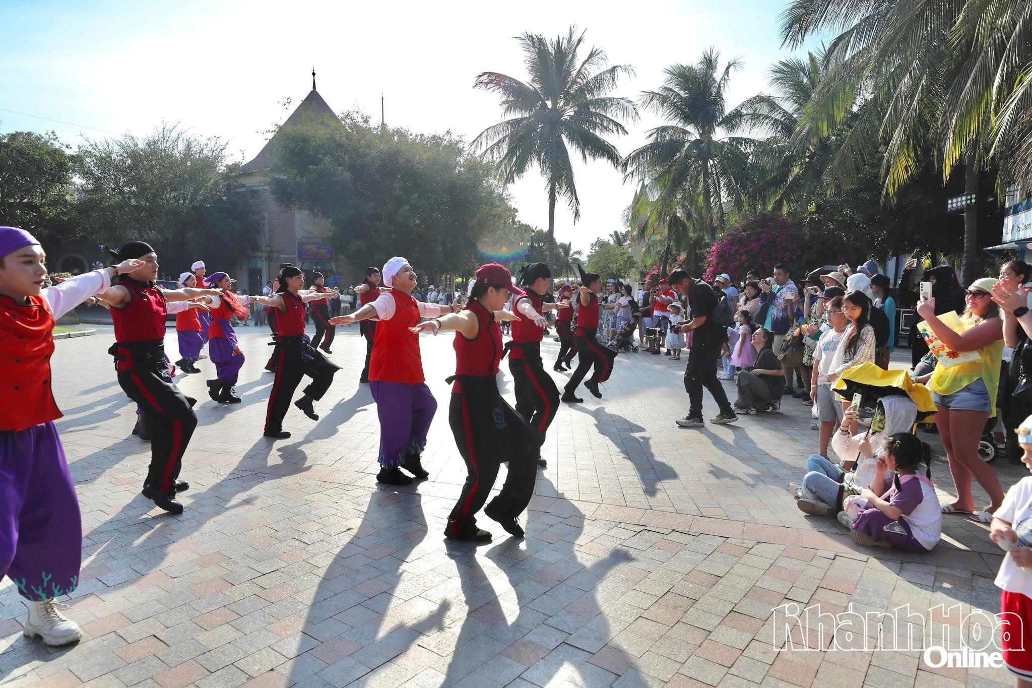 Khách du lịch theo dõi đội vũ công nhảy múa tại VinWonders Nha Trang.