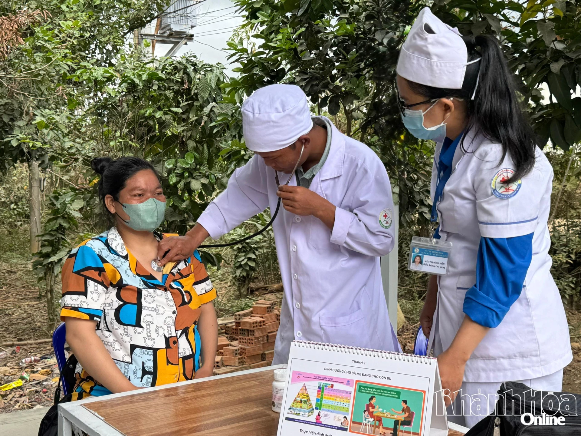 Nhân viên Trung tâm Y tế khu vực Khánh Sơn khám bệnh và tư vấn dinh dưỡng tại nhà cho sản phụ.