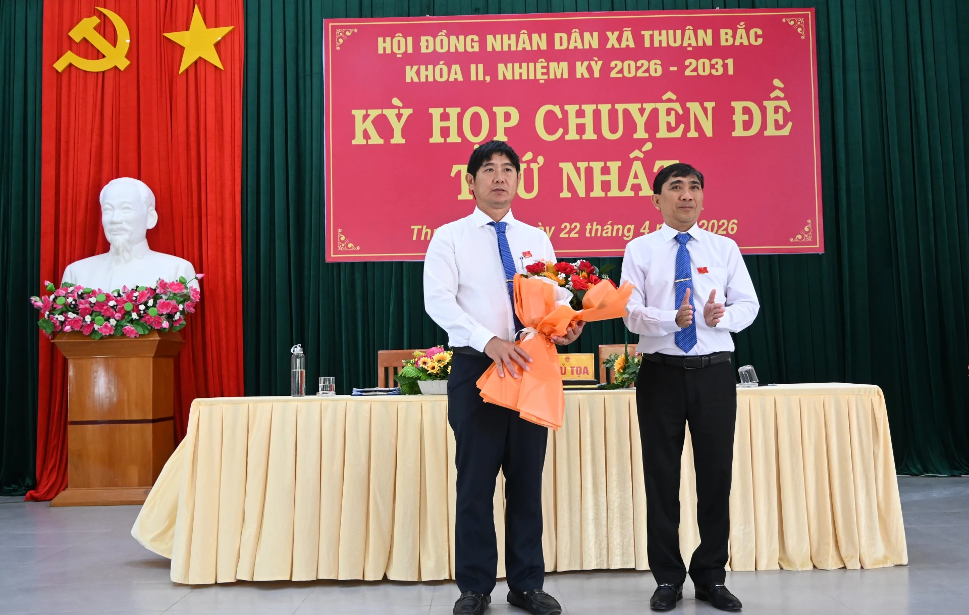 Ông Hồ Sĩ Sơn - Bí thư Đảng ủy, Chủ tịch HĐND xã tặng hoa chúc mừng ông Phạm Trọng Hùng.