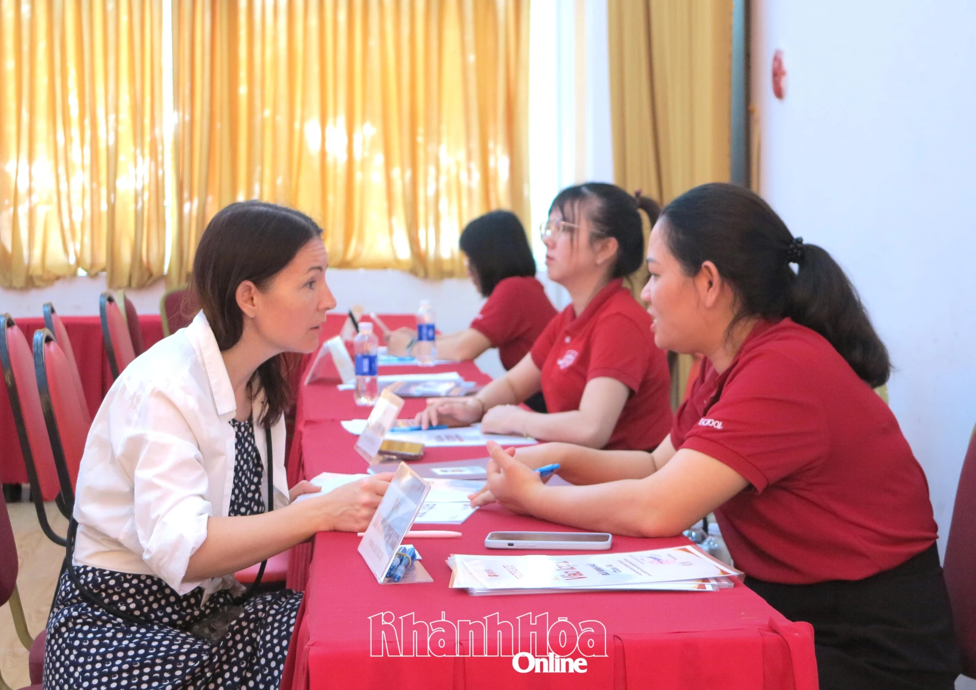 Phụ huynh học sinh tìm hiểu thông tin tuyển sinh tại bàn tư vấn trực tiếp. 