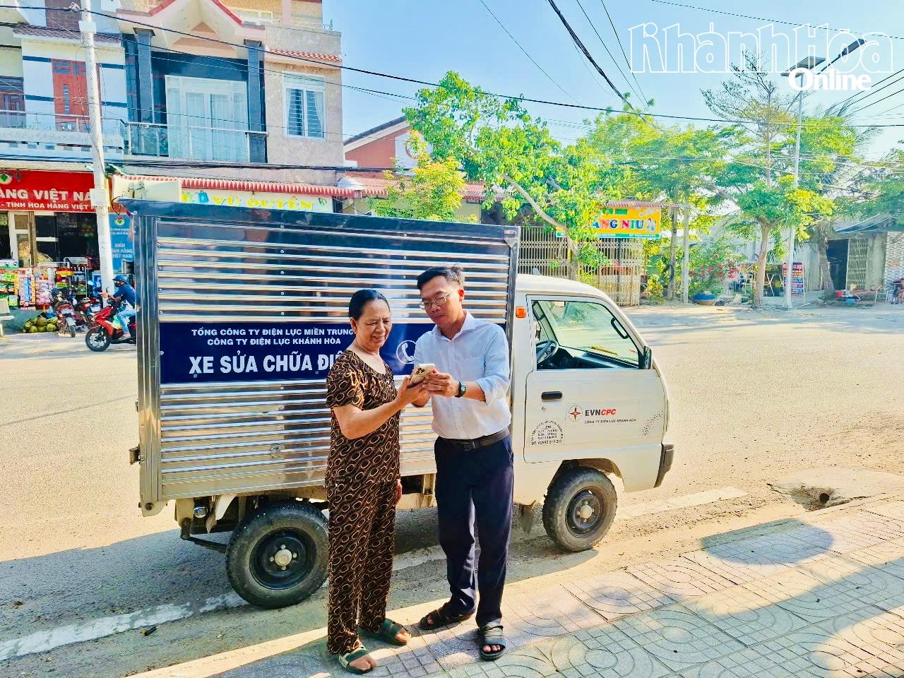 Nhân viên Công ty Điện lực Khánh Hòa hướng dẫn khách hàng theo dõi sản lượng điện tiêu thụ qua ứng dụng.