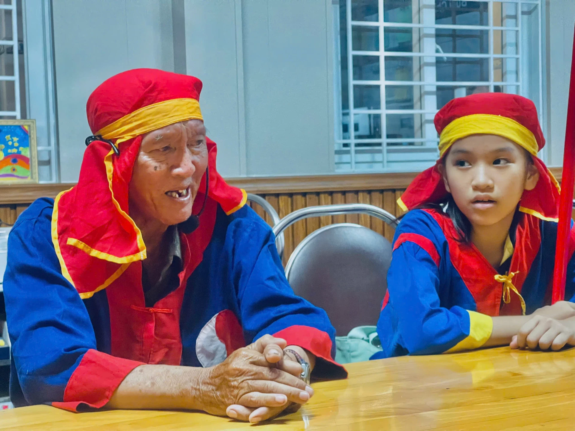 Ông Nguyễn Văn Hảo (bên trái) đang chỉ dạy cách hát cho các em.