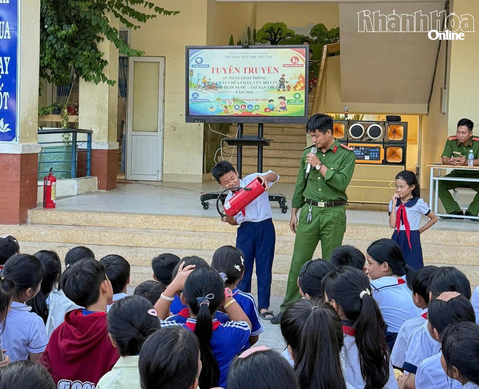 Các em học sinh được hướng dẫn kỹ năng sử dụng bình chữa cháy xách tay để dập lửa.