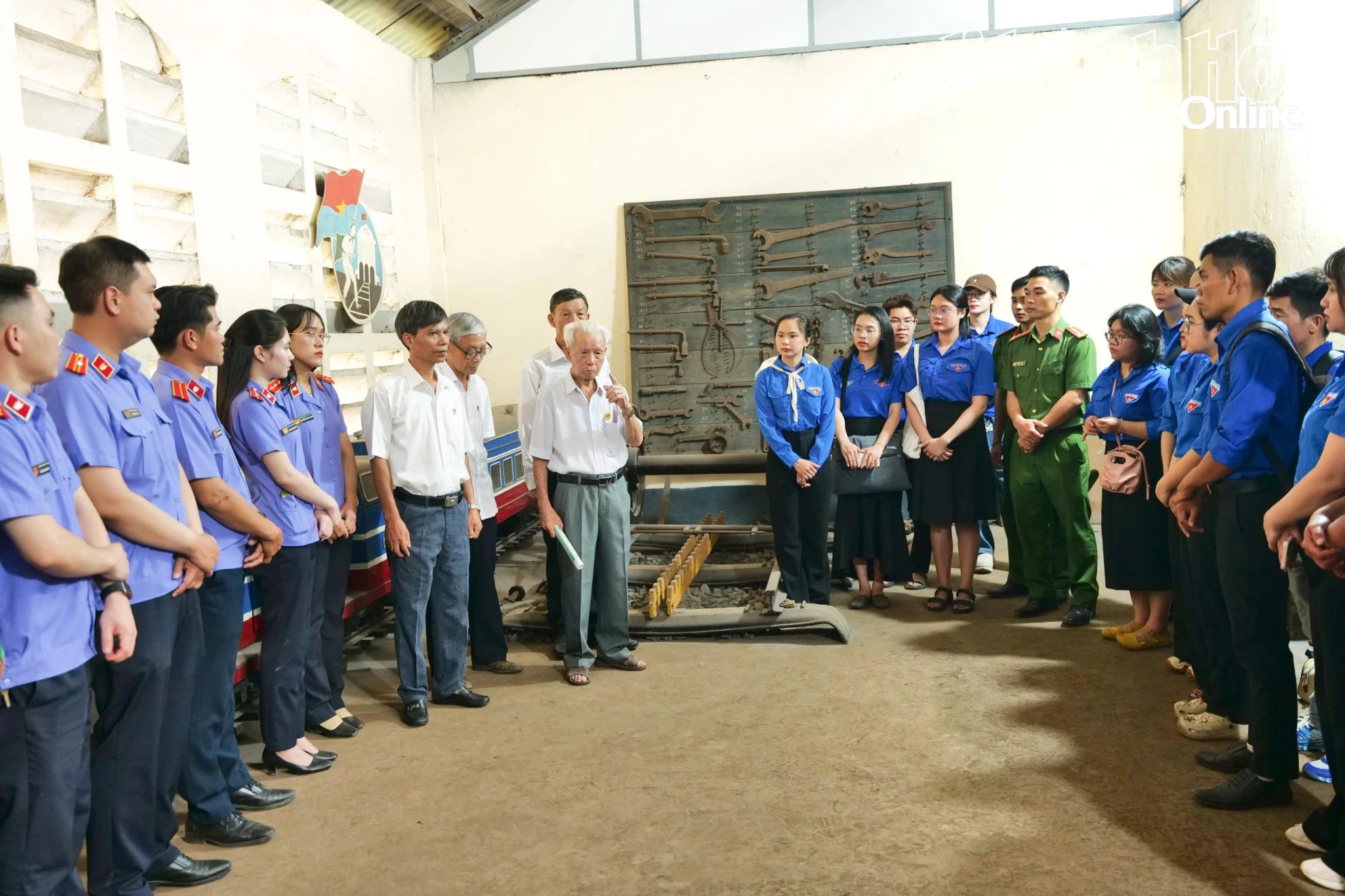 Đoàn viên, thanh niên nghe cán bộ lão thành kể chuyện, giới thiệu về lịch sử di tích Đề pô xe lửa Tháp Chàm. Ảnh: THANH XUÂN