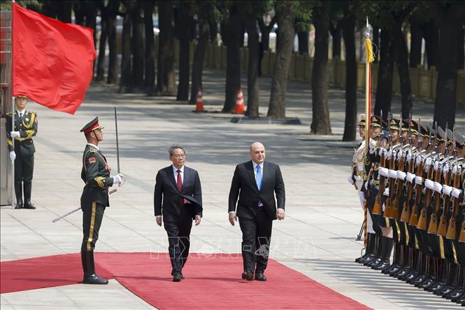 Thủ tướng Nga Mikhail Mishustin (giữa, phải) và Thủ tướng Trung Quốc Lý Cường (giữa, trái) duyệt đội danh dự tại Bắc Kinh ngày 24/5/2023. Ảnh: Kyodo/TTXVN

