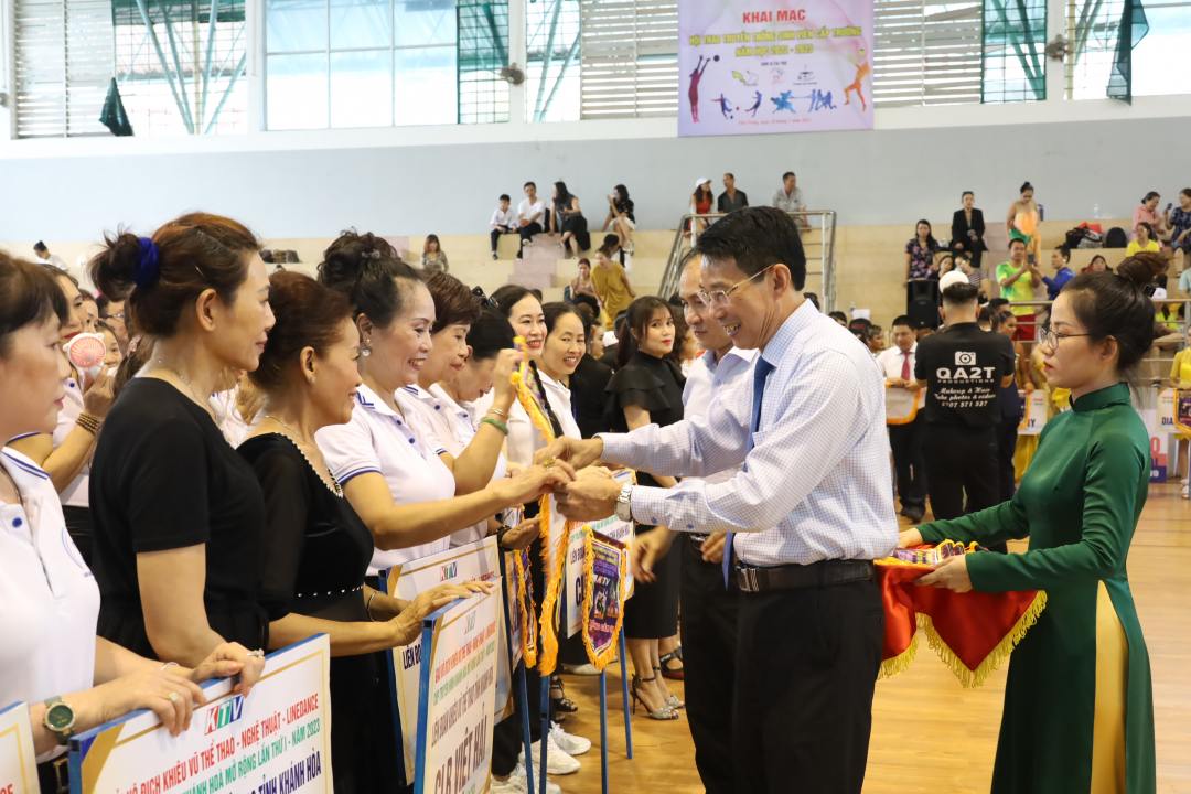 Dinh Van Thieu offering souvenir flags to teams
