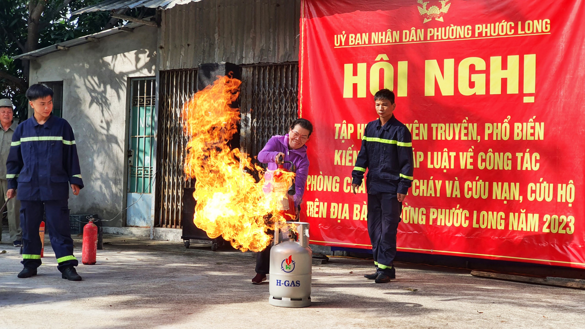 Đại diện một tổ dân phố được thực hành kỹ năng dùng bình chữa cháy để dập đám cháy