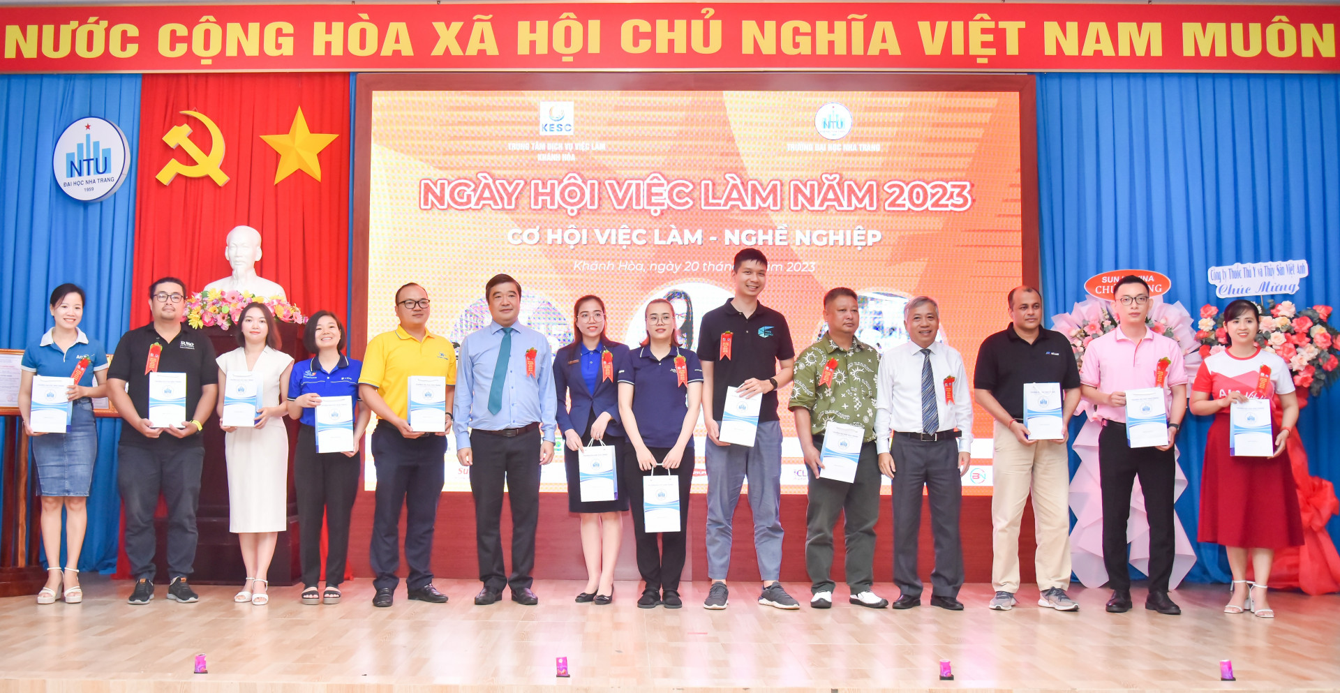 Ông Tạ Hồng Quang - Giám đốc Sở Lao động - Thương binh và Xã hội và lãnh đạo Trường Đại học Nha Trang tặng quà lưu niệm cho các đơn vị, doanh nghiệp tham gia ngày hội.