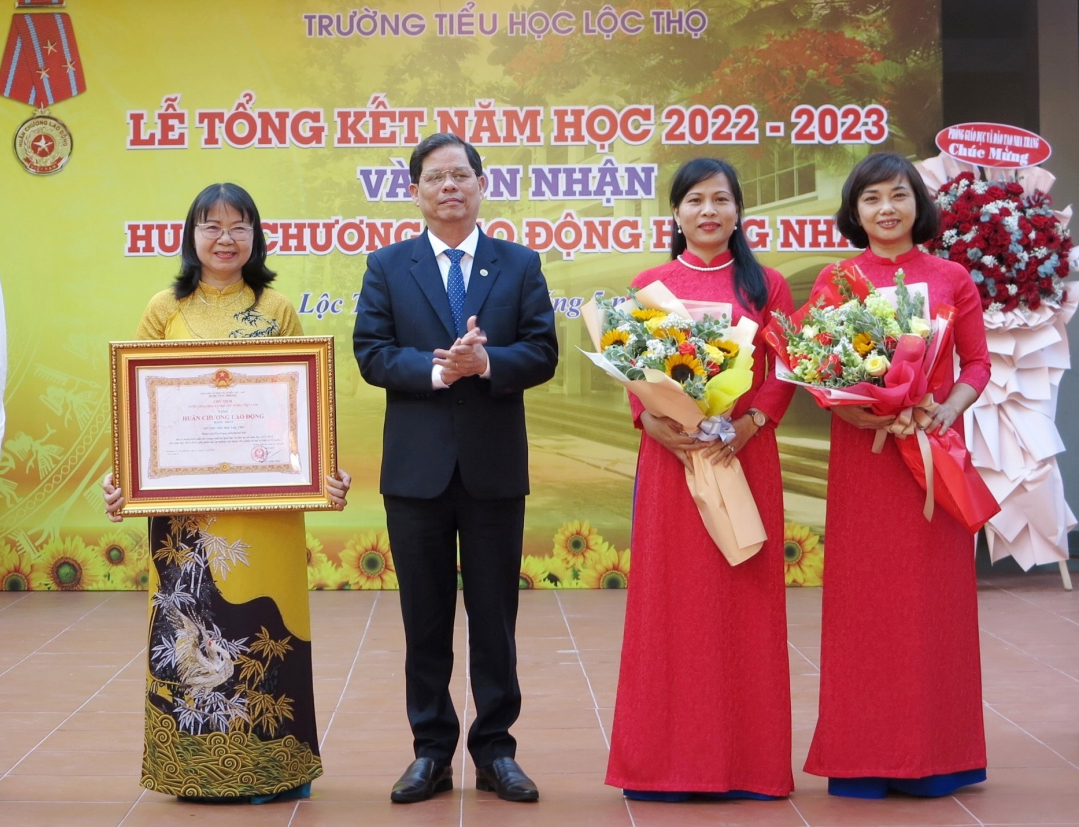 Ông Nguyễn Tấn Tuân trao Huân chương Lao động hạng Nhất của Chủ tịch nước cho nhà trường.