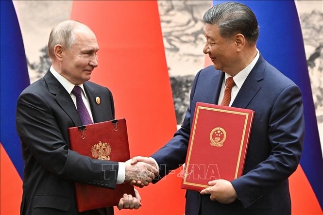 Chủ tịch Trung Quốc Tập Cận Bình (phải) và Tổng thống Nga Vladimir Putin trao đổi văn kiện hợp tác tại lễ ký tuyên bố chung ở Bắc Kinh, ngày 16-5. Ảnh: TTXVN 
