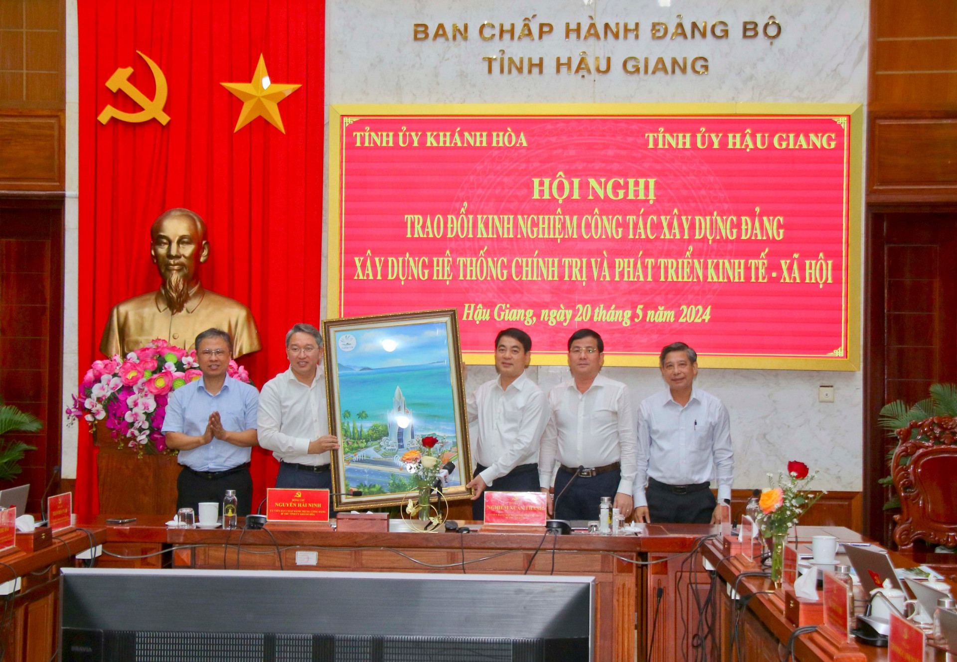 Đoàn công tác Tỉnh uỷ Khánh Hoà (bên trái) tặng tranh lưu niệm đến Thường trực Tỉnh uỷ Hậu Giang.

