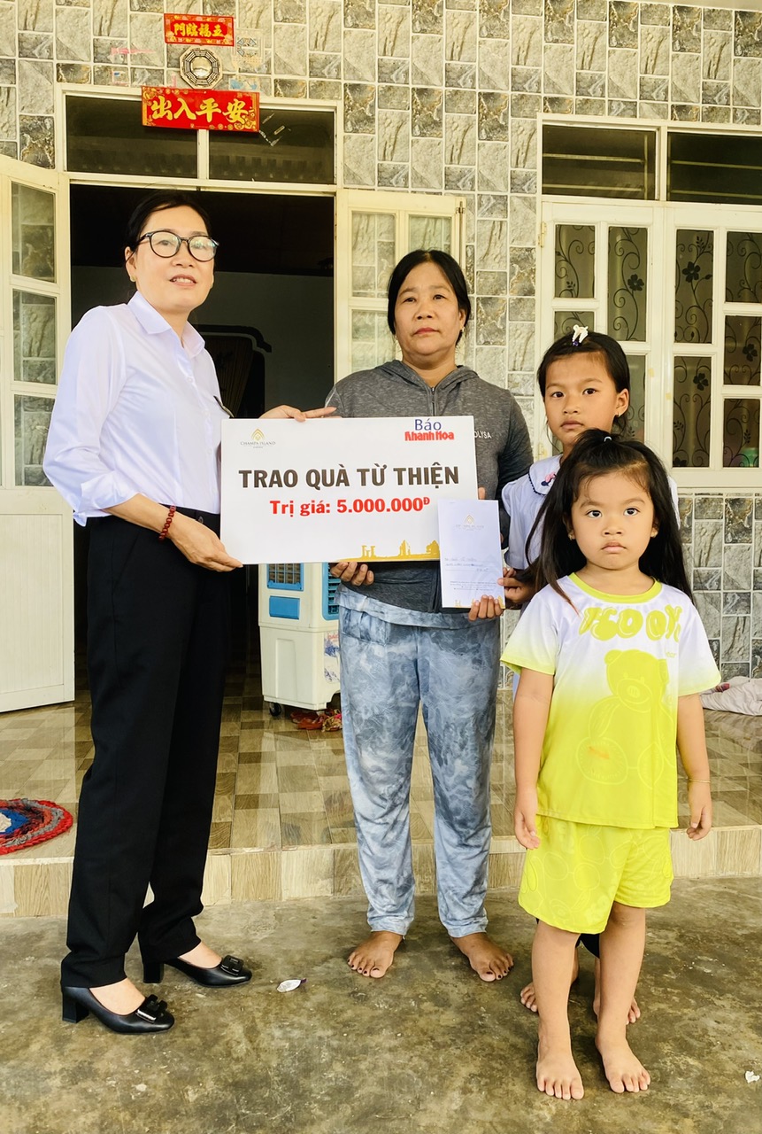 Đại diện Công ty Cổ phần Đầu tư Champagroup - Khu du lịch Champa Island Nha Trang trao tiền ủng hộ cho gia đình hai cháu Diễm Quỳnh và Khả Hân