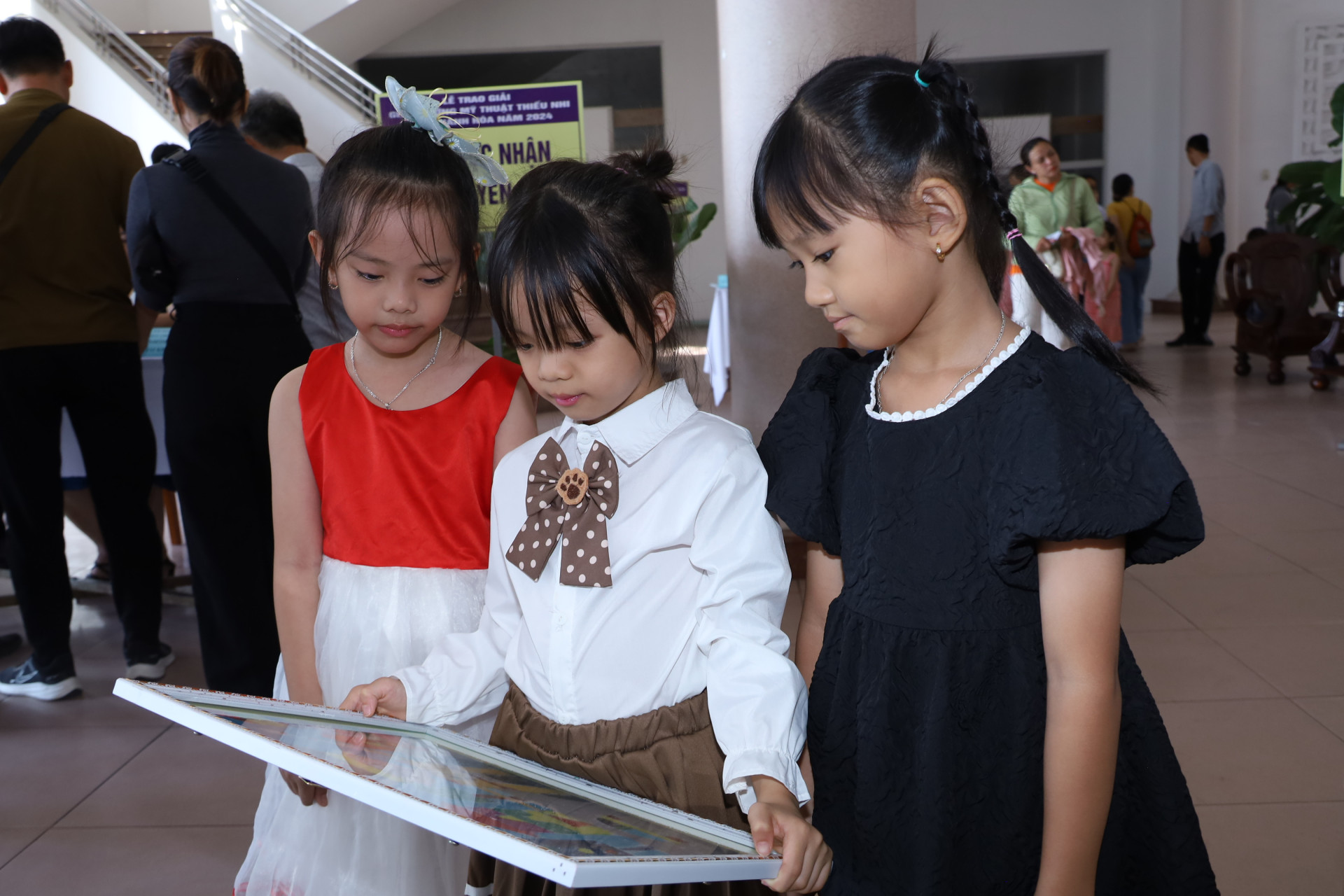 Các em xem tác phẩm của mình tại lễ trao giải.