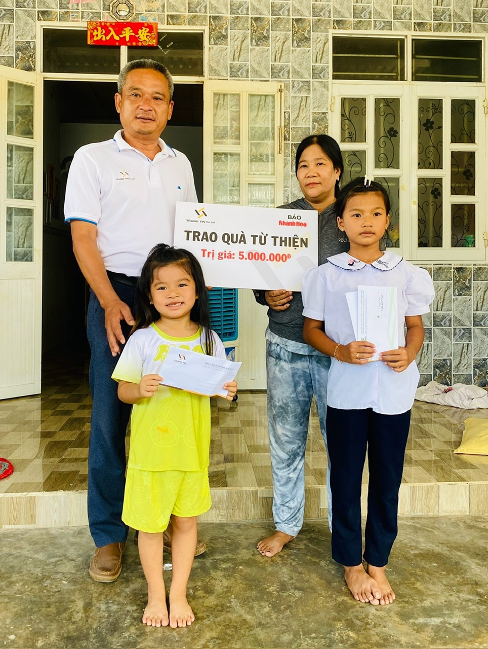 Ông Trần Khánh Định - Phó Giám đốc Công ty TNHH Tư vấn và Đầu tư Trung Tín trao tiền ủng hộ cho gia đình hai cháu Diễm Quỳnh và Khả Hân