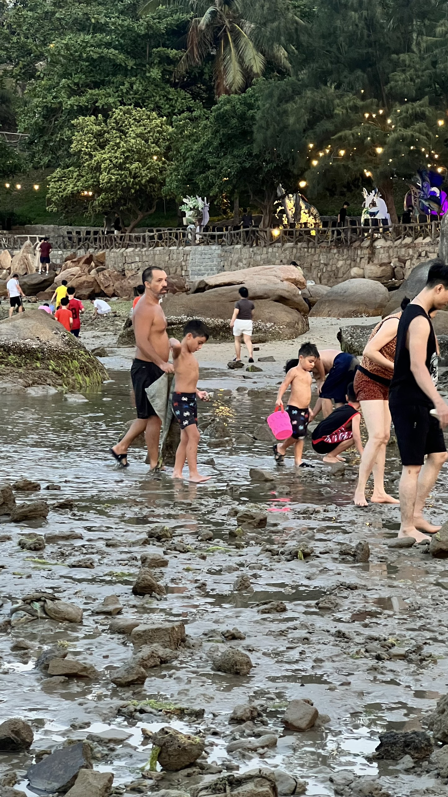 Nhiều người dân và du khách vui lội ra xa bờ để vui chơi ở khu vực biển Hòn Chồng - Đặng Tất khi thủy triều rút.