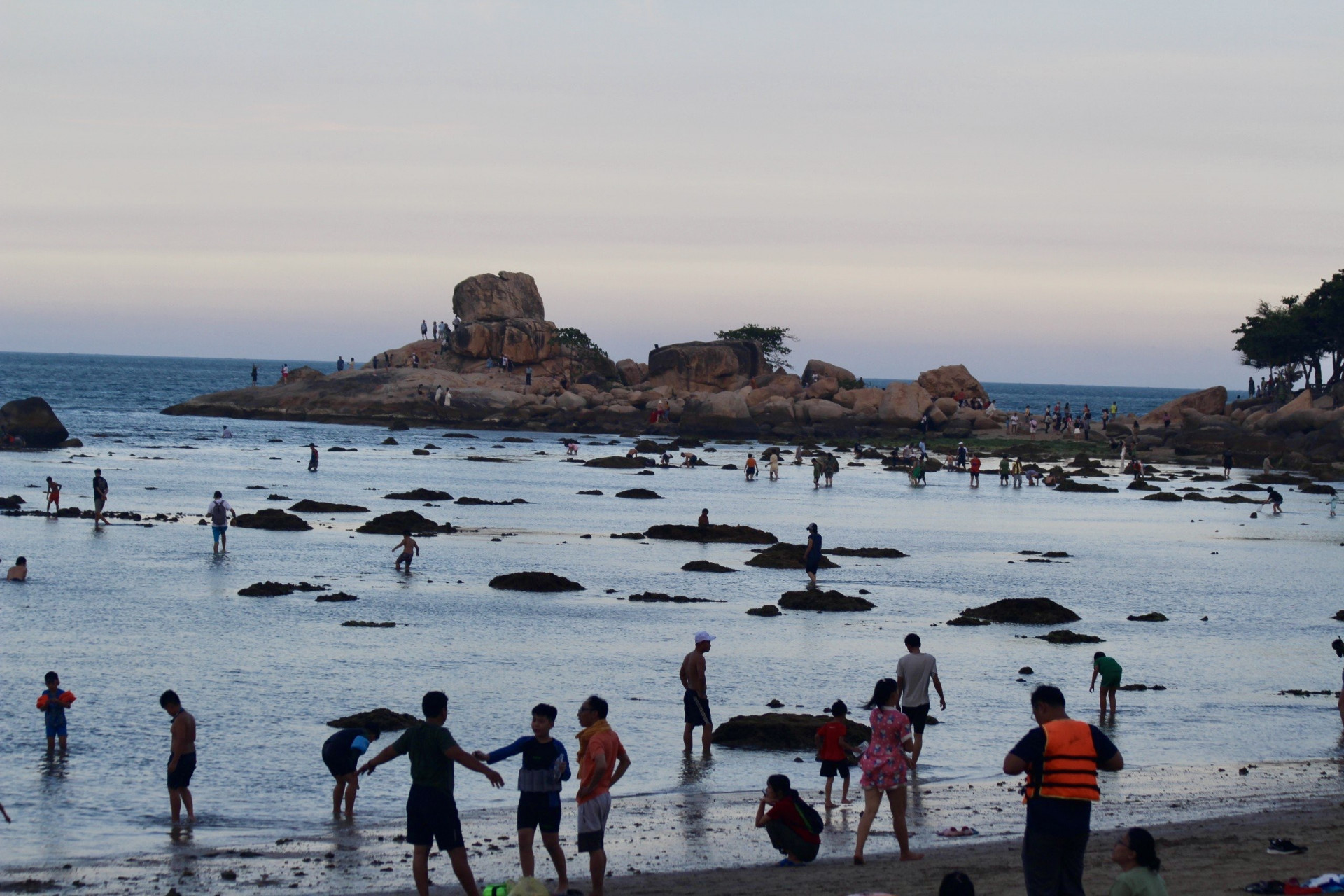 Nhiều người dân và du khách lội ra xa vui chơi khi thủy triều rút ở khu vực biển Hòn Chồng.